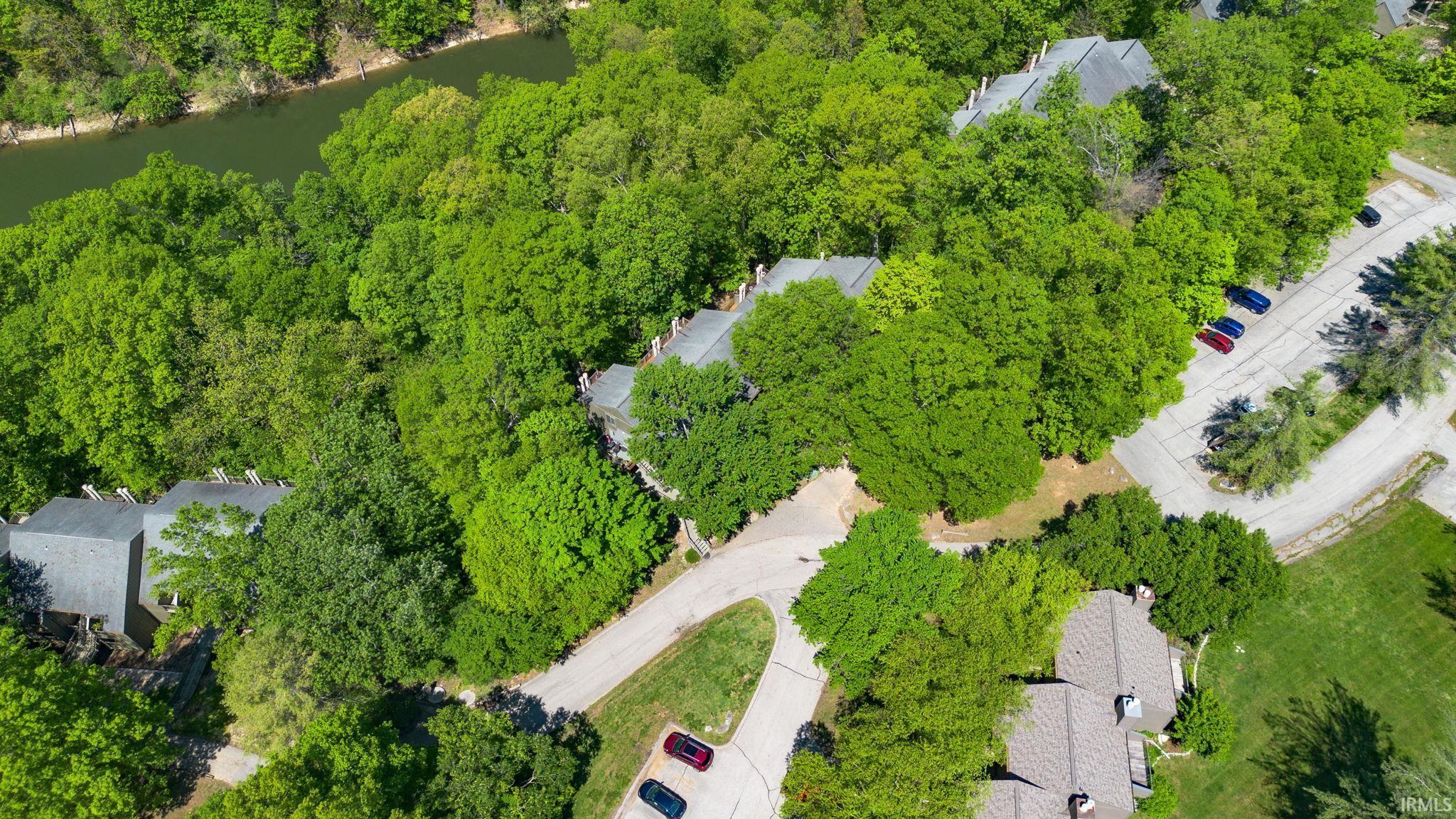 Image 2: Aerial perspective of a multi-unit property set among dense green foliage, Aerial View