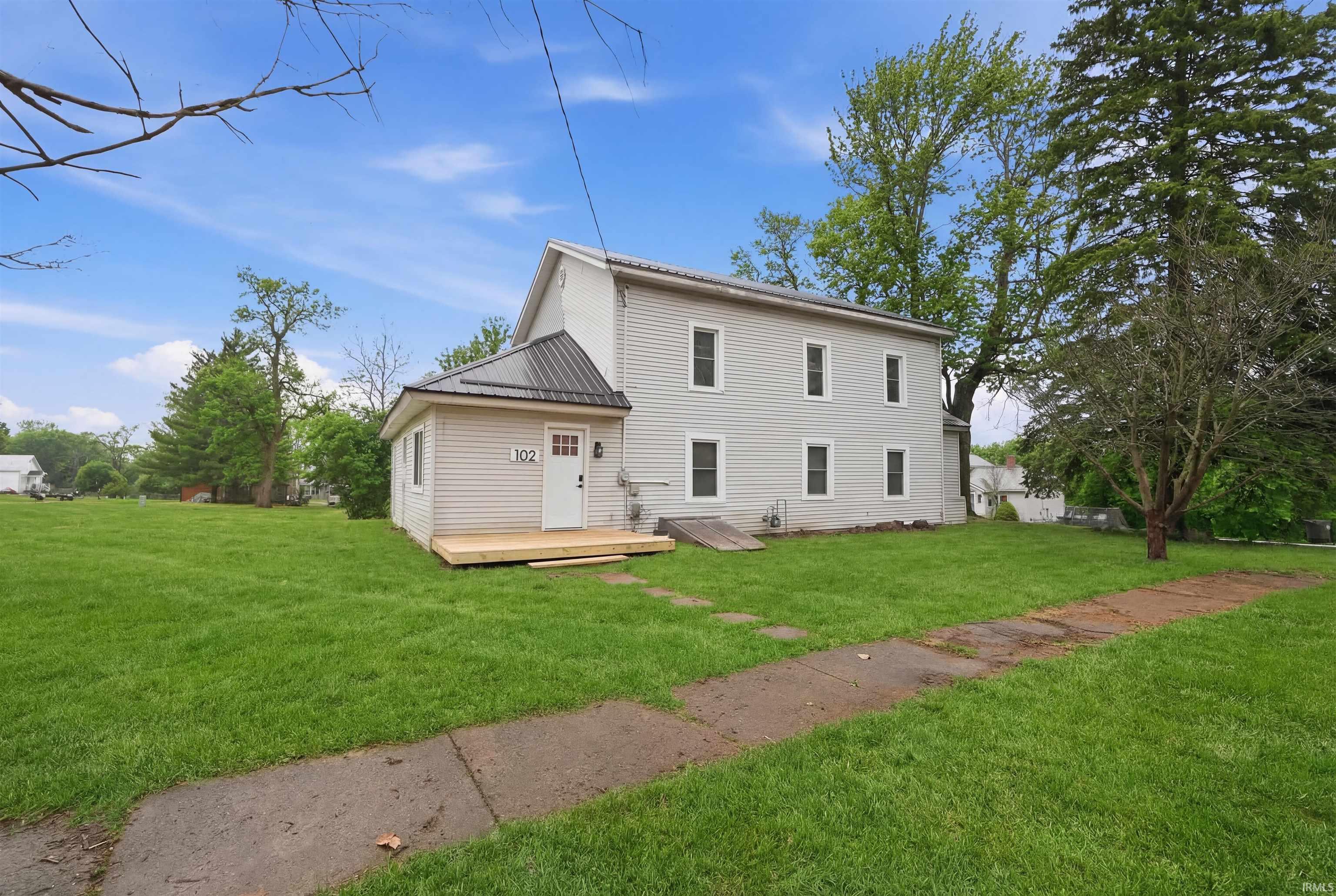 Image 0: Rear view of property with a lawn, a metal roof, and a wooden deck, Porch Front