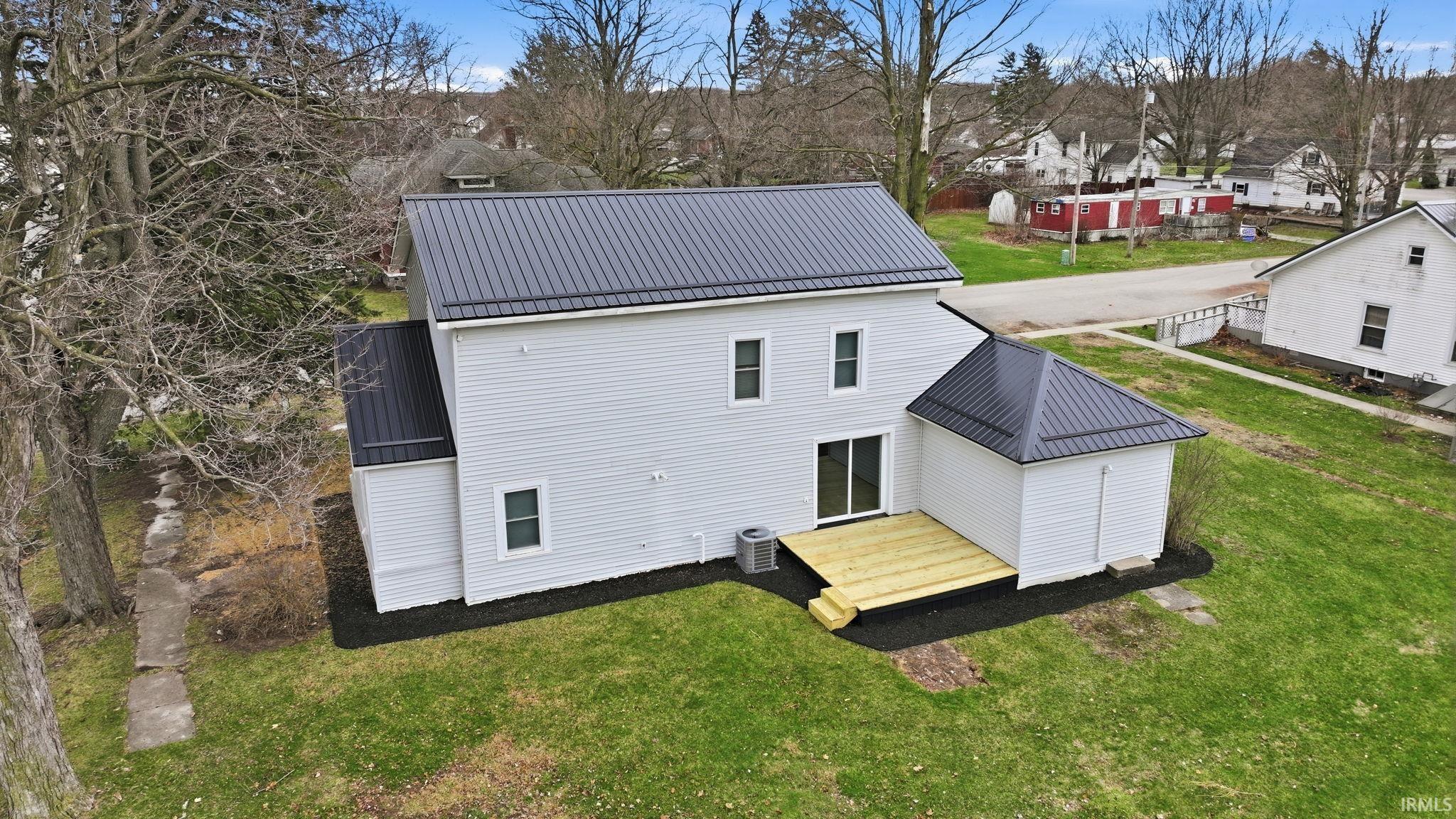 Image 2: Back of property featuring a metal roof and a lawn, Back Of Structure