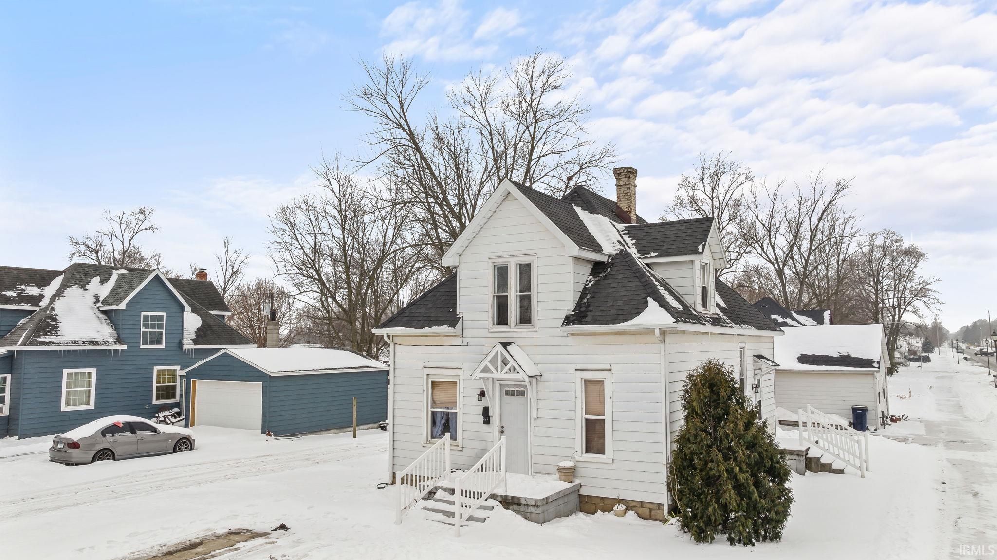 Image 2: View of front facade with a chimney, a garage, and an outbuilding, Front Of Structure