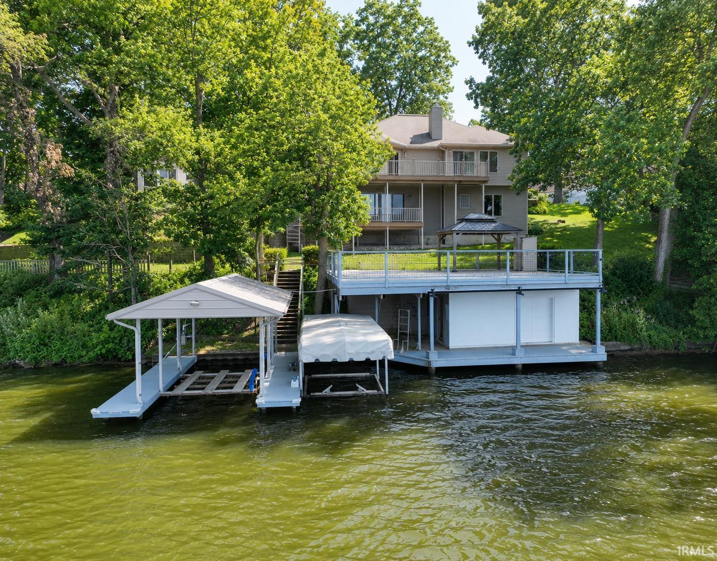 Image 1: Waterfront property featuring a covered boat dock, multi-level decking, and a covered patio area, Dock Image 1: Waterfront property featuring a covered boat dock, multi-level decking, and a covered patio area, Dock