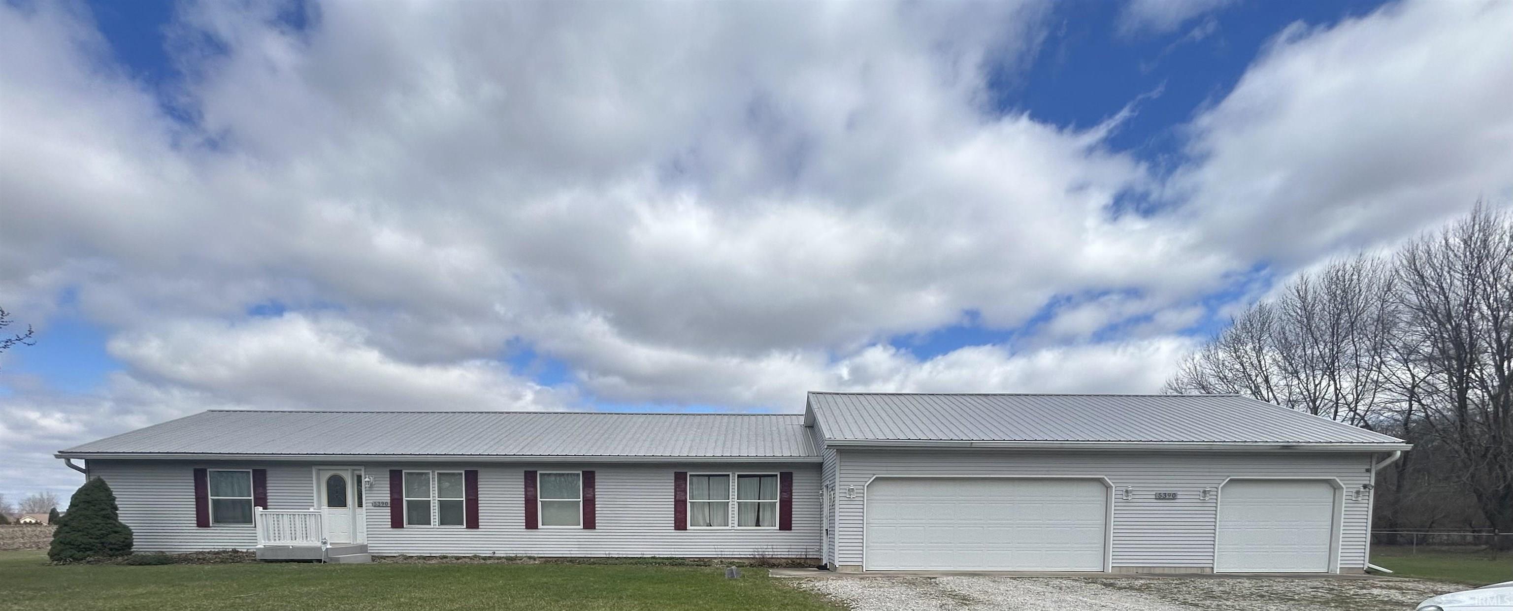 Image 0: Ranch-style home featuring a metal roof, an attached garage, and driveway, Front Of Structure
