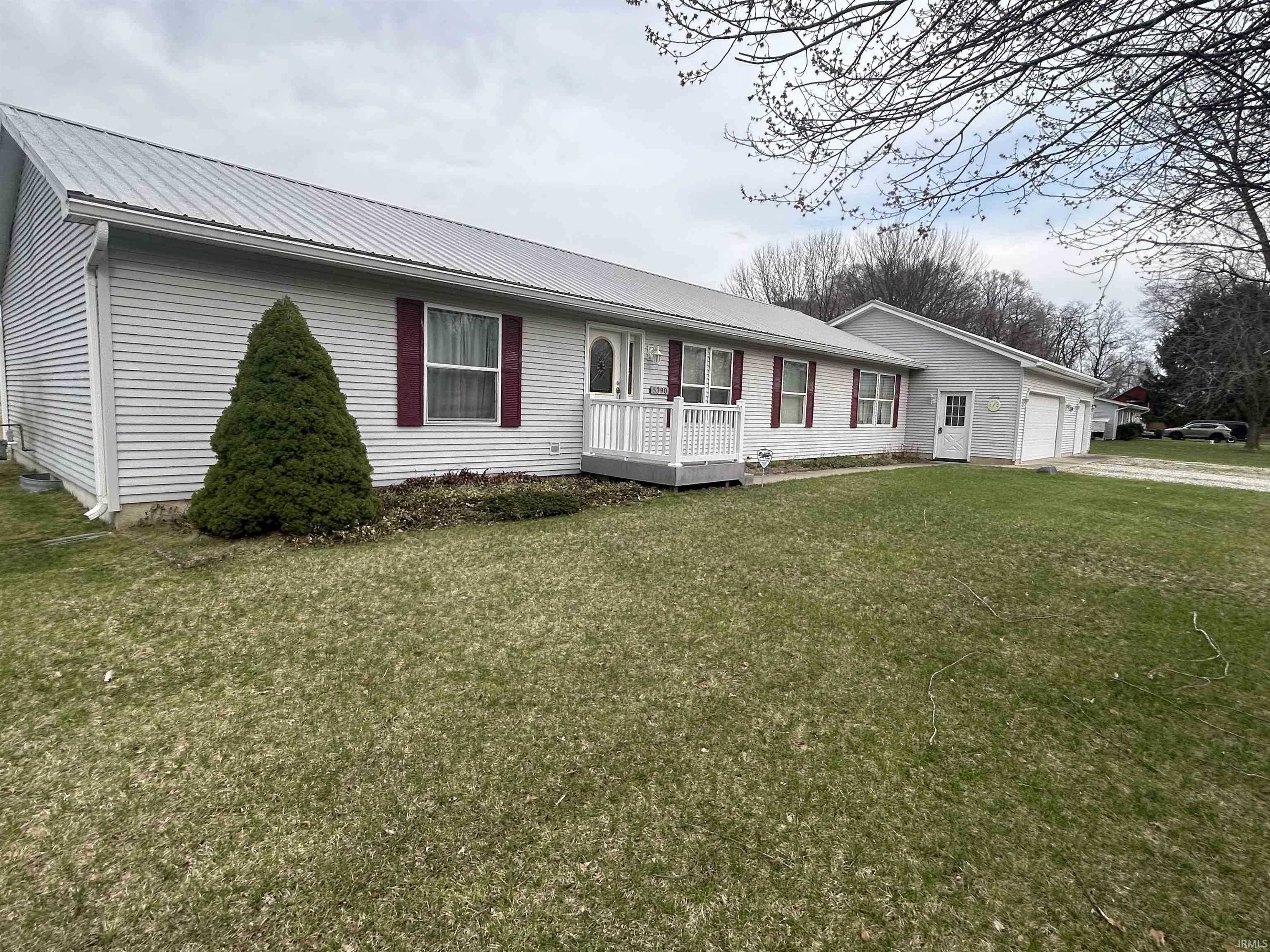 Image 1: Ranch-style home featuring a front yard, a metal roof, driveway, and an attached garage, Front Of Structure