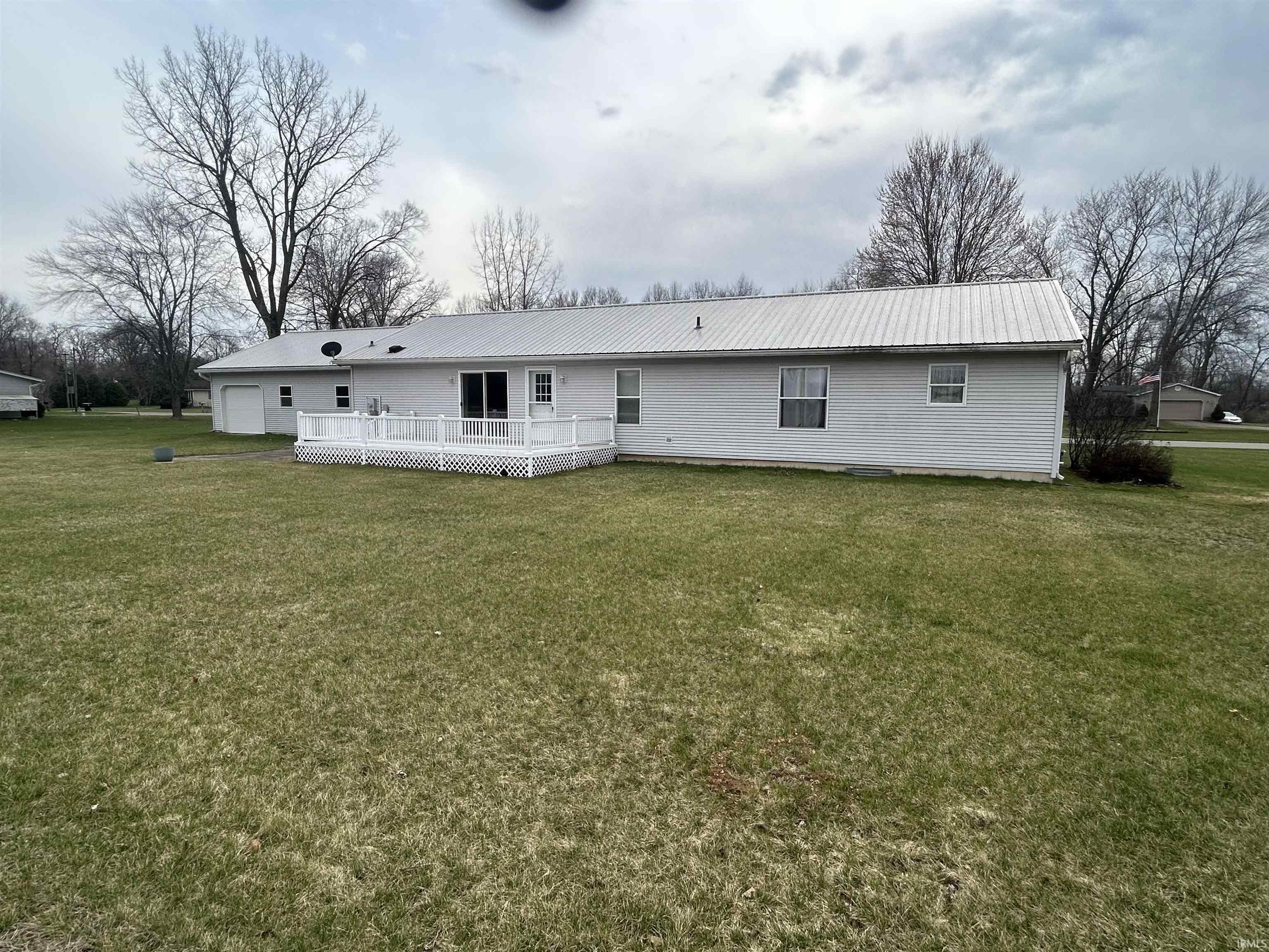 Image 2: Back of house featuring a deck, a yard, and a metal roof, Back Of Structure