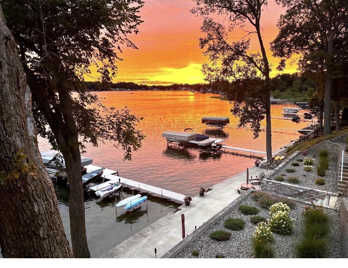 Image 1: Waterfront property featuring a concrete seawall, multiple docks, and a boat lift, View Image 1: Waterfront property featuring a concrete seawall, multiple docks, and a boat lift, View