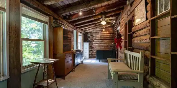 Image 1: Rustic interior hallway featuring exposed log walls, a wood-planked vaulted ceiling, and recessed lighting, Den Image 1: Rustic interior hallway featuring exposed log walls, a wood-planked vaulted ceiling, and recessed lighting, Den