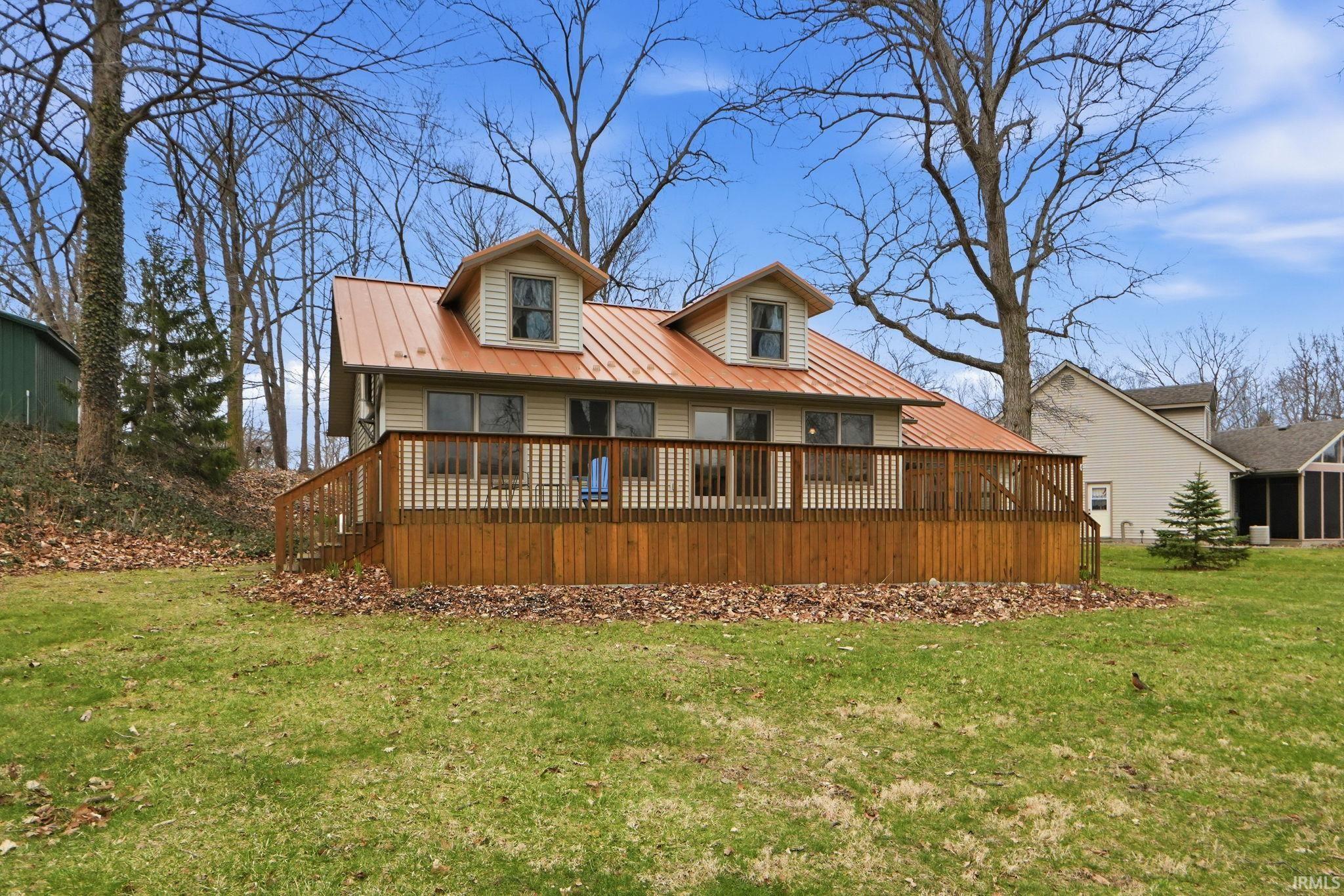 Image 2: Rear view of house featuring a deck, a yard, and a metal roof, Back Of Structure