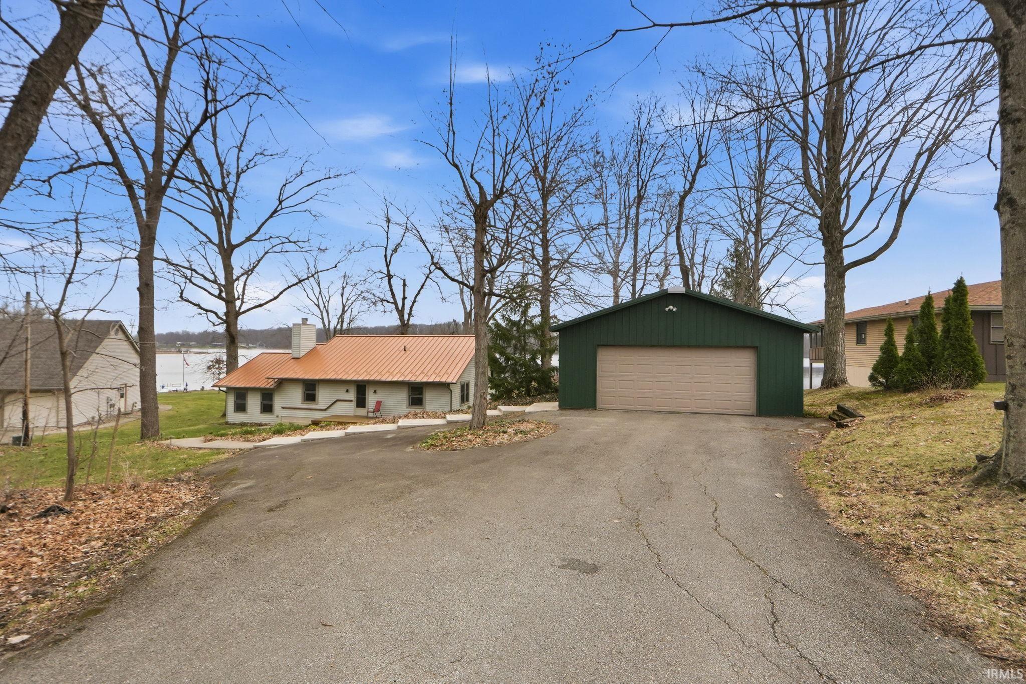 Image 3: View of front facade with an outbuilding, a chimney, a detached garage, and a metal roof, Front Of Structure