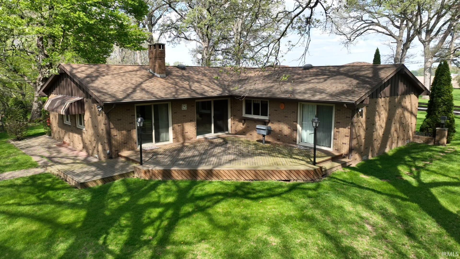 Image 1: Brick exterior with a large wood-finish deck, Back Of Structure Image 1: Brick exterior with a large wood-finish deck, Back Of Structure
