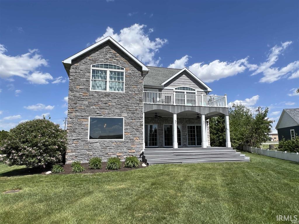 Image 0: Rear view of property featuring a lawn, a patio, and stone siding, Back Of Structure