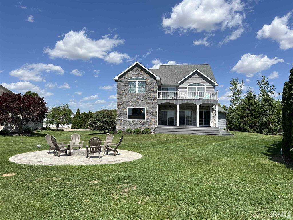 Image 1: Rear view of property with a patio, stone siding, a yard, and an outdoor fire pit, Back Of Structure