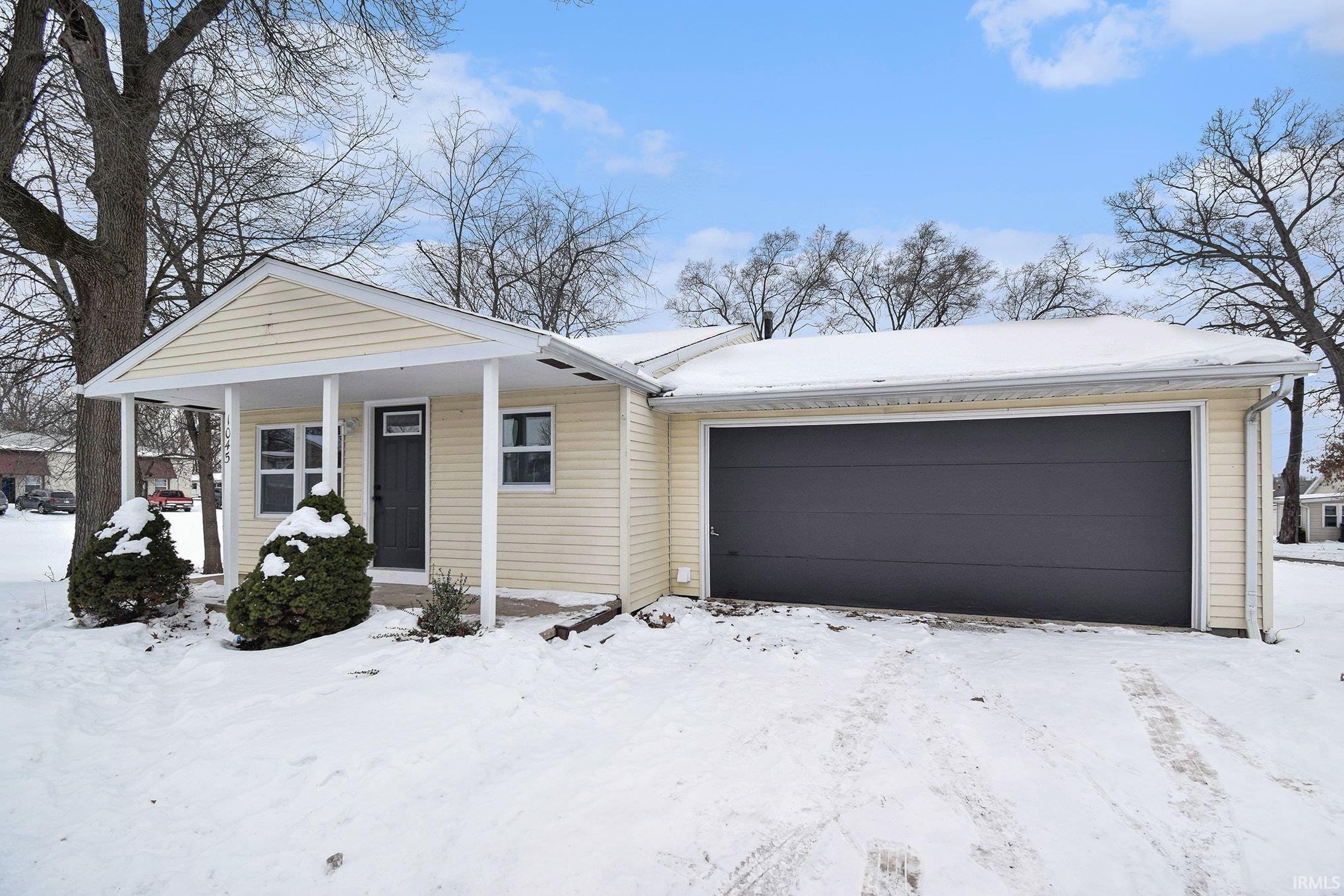 Image 0: View of front of house featuring a porch and a garage Image 0: View of front of house featuring a porch and a garage