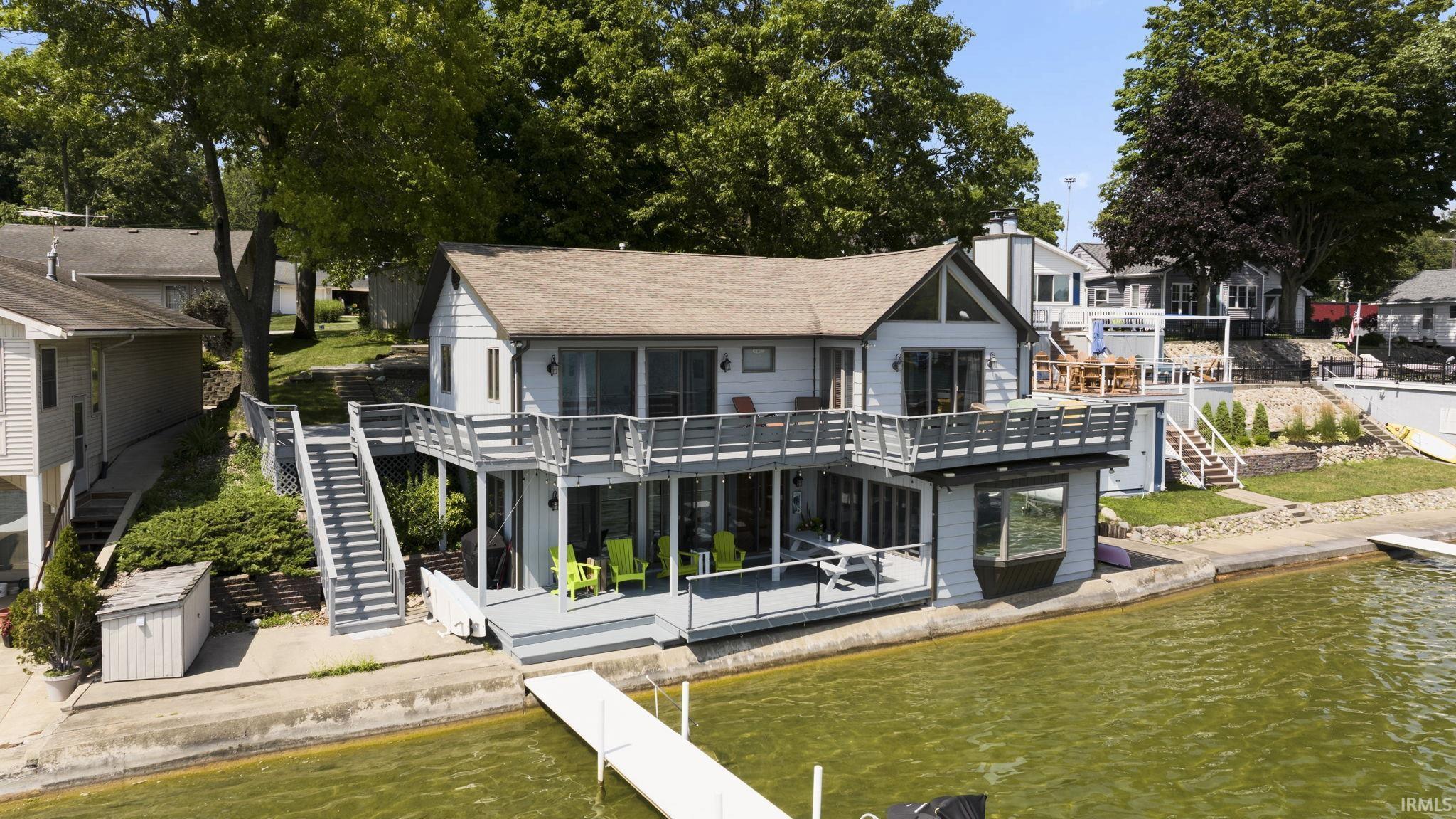 Image 0: Back of house with a patio, a deck with water view, and a residential view, Back Of Structure Image 0: Back of house with a patio, a deck with water view, and a residential view, Back Of Structure