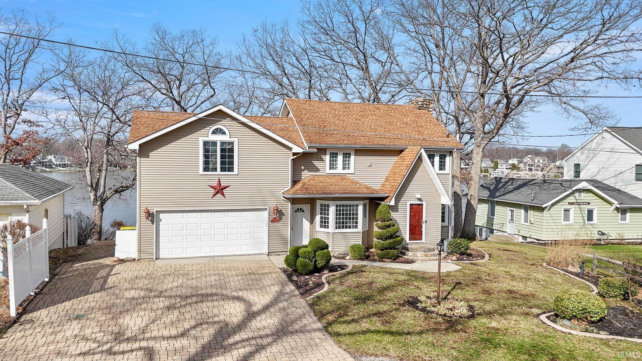 Image 2: Traditional home with decorative driveway, an attached garage, and a shingled roof, Front Of Structure Image 2: Traditional home with decorative driveway, an attached garage, and a shingled roof, Front Of Structure