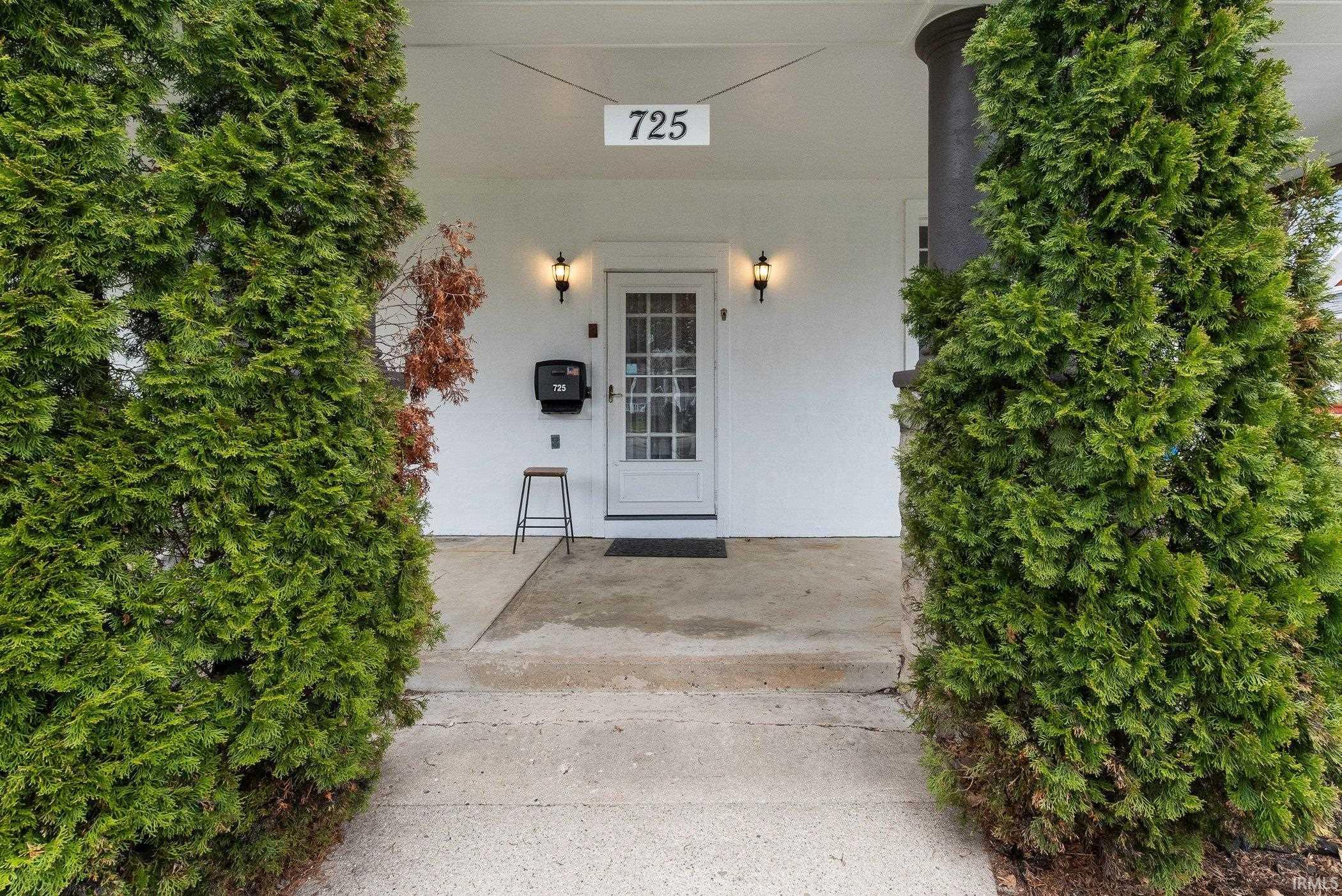 Image 1: Doorway to property with stucco siding, Entry