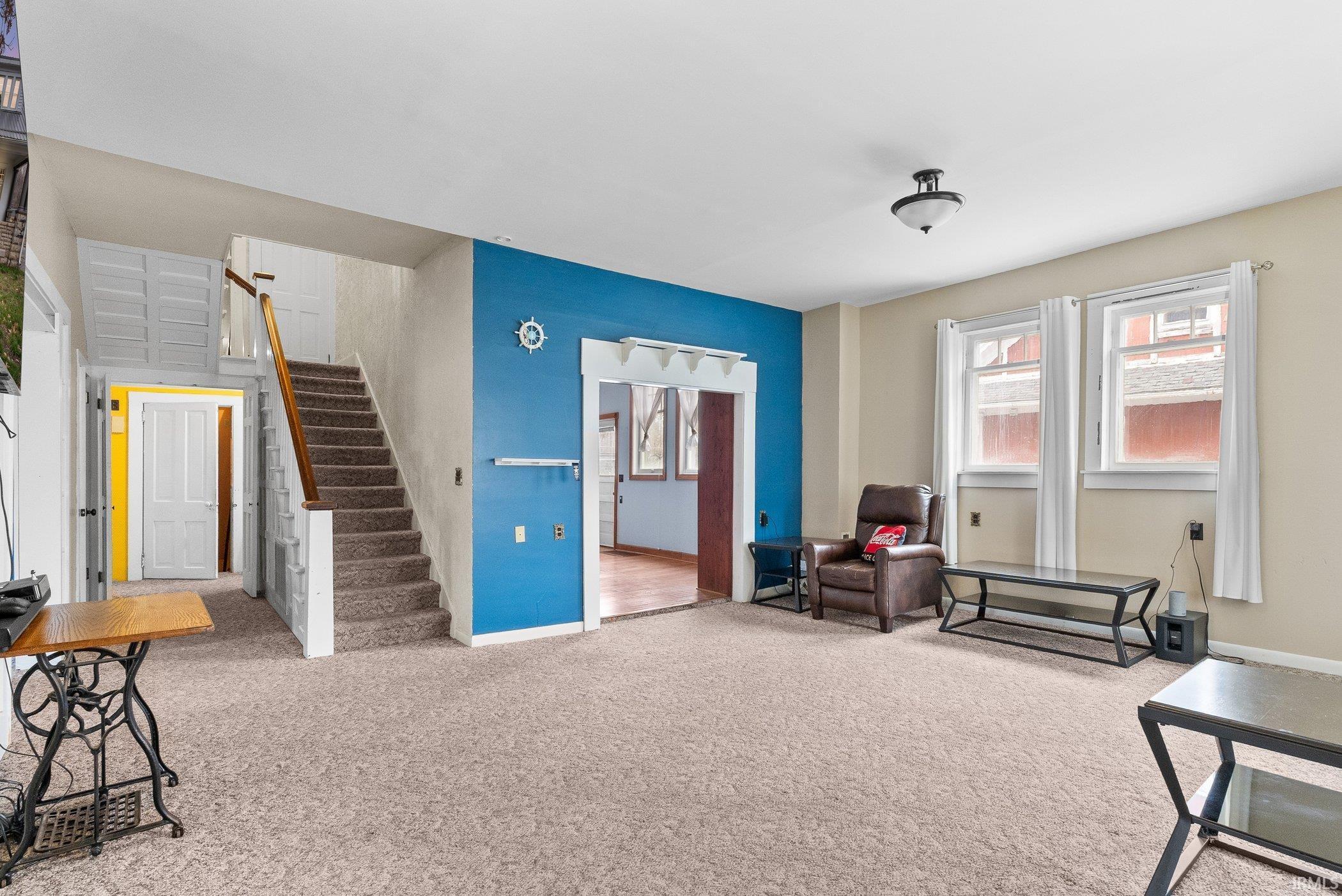 Image 3: Living area with stairway and light carpet, Living Room