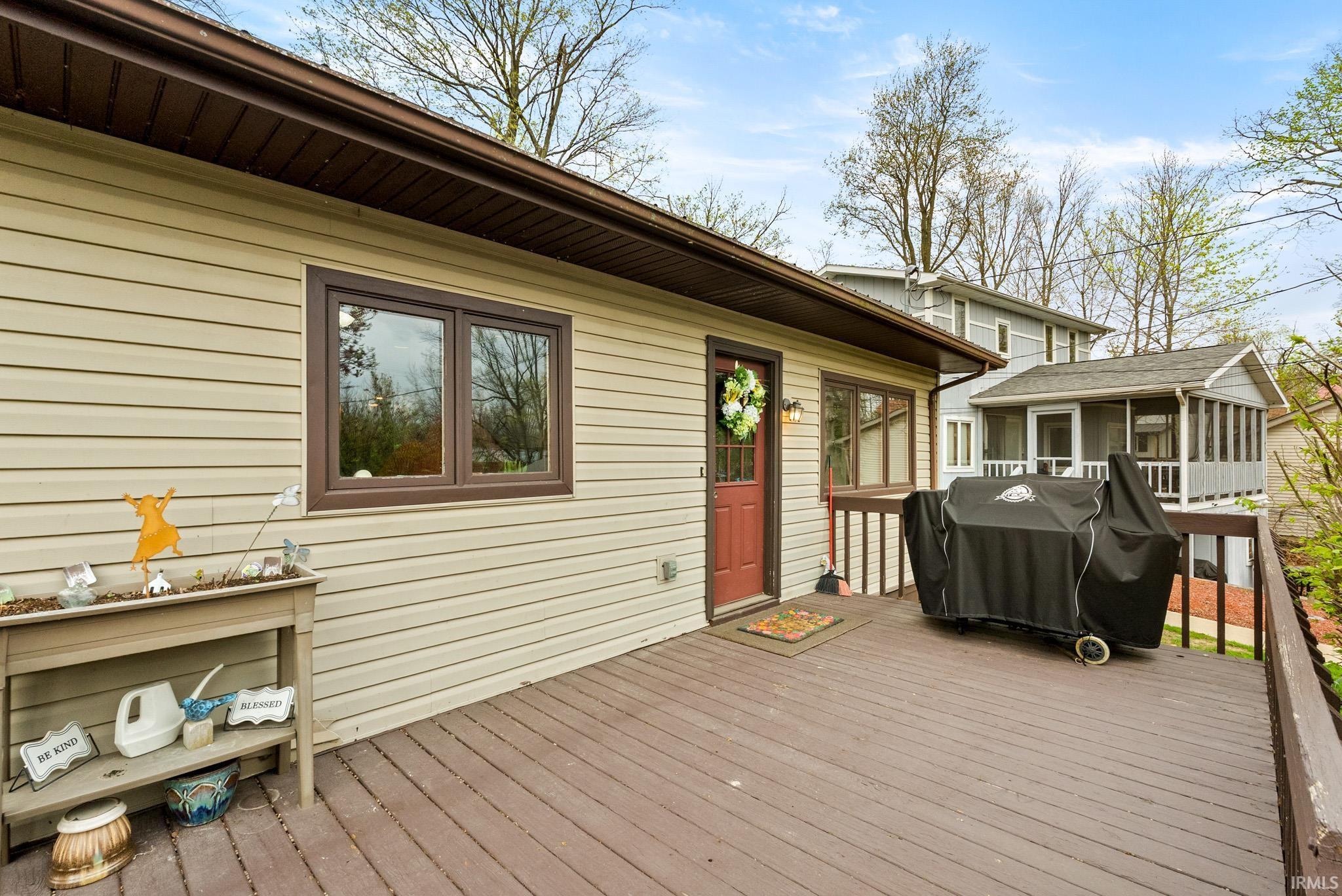Image 3: Wooden deck featuring area for grilling and a sunroom, Deck