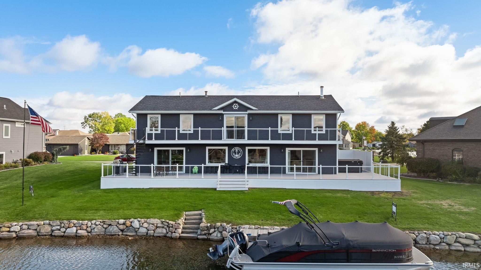 Image 0: Rear view of house featuring a water view and a yard, Back Of Structure Image 0: Rear view of house featuring a water view and a yard, Back Of Structure