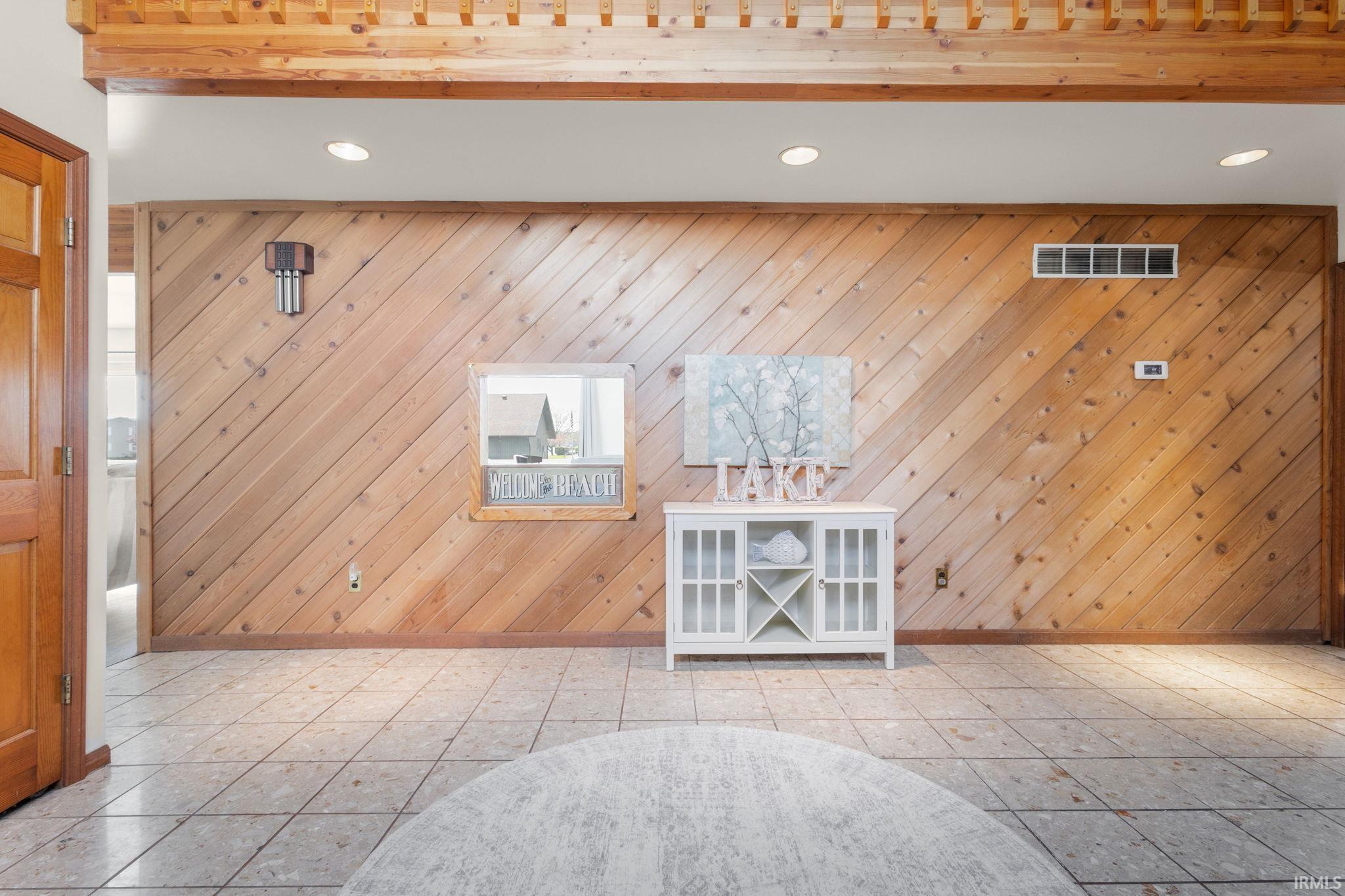 Image 3: Unfurnished living room with recessed lighting, wood walls, and tile patterned floors, Living Room Image 3: Unfurnished living room with recessed lighting, wood walls, and tile patterned floors, Living Room