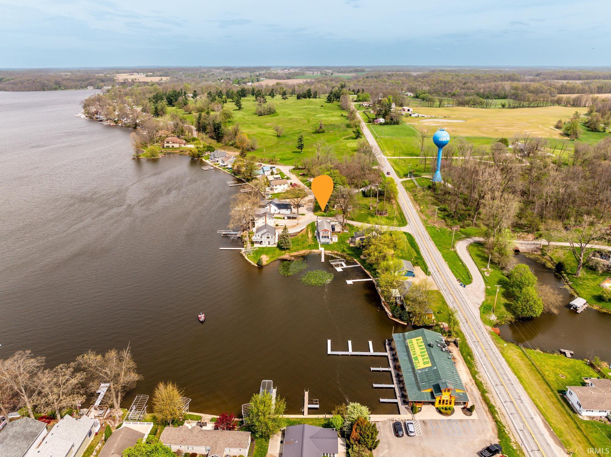 Image 1: Waterfront property featuring a private dock, green landscaping, and direct access to a large lake, Aerial View