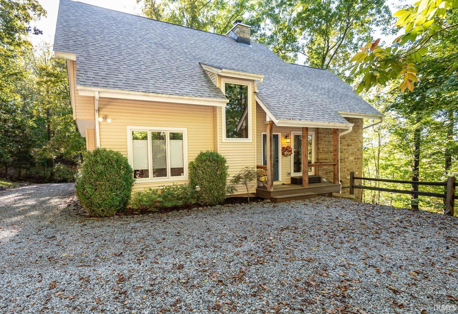 Image 1: View of front of house with a shingled roof, a chimney, and stone siding, Front Of Structure
