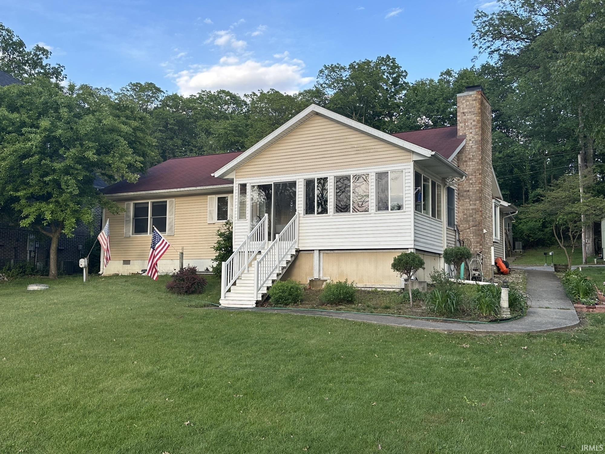 Image 0: View of front of home with a front lawn, entry steps, a chimney, a sunroom, and crawl space, Front Of Structure