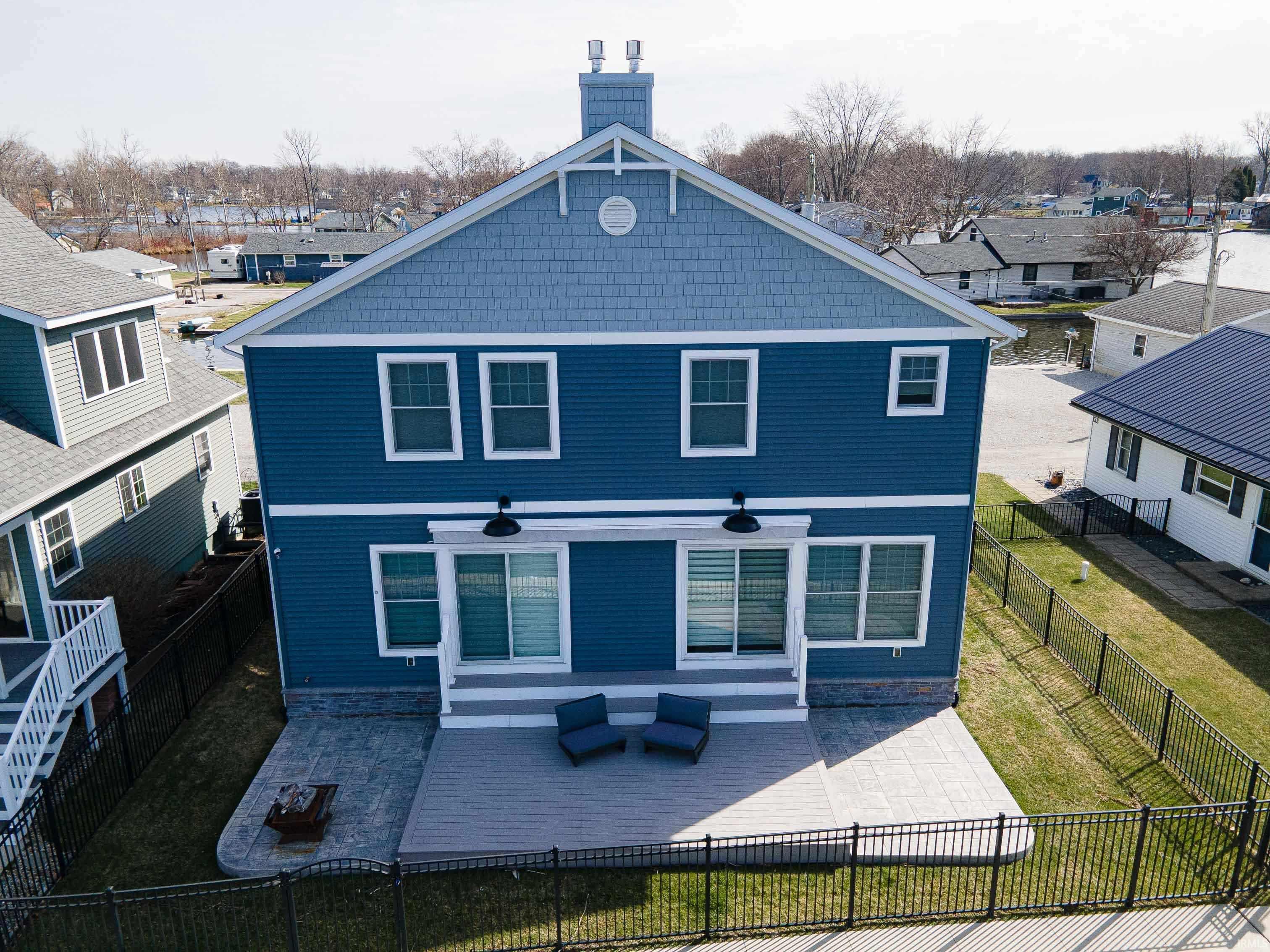 Image 0: Back of property featuring a chimney, a residential view, a patio, and a fenced backyard, Back Of Structure