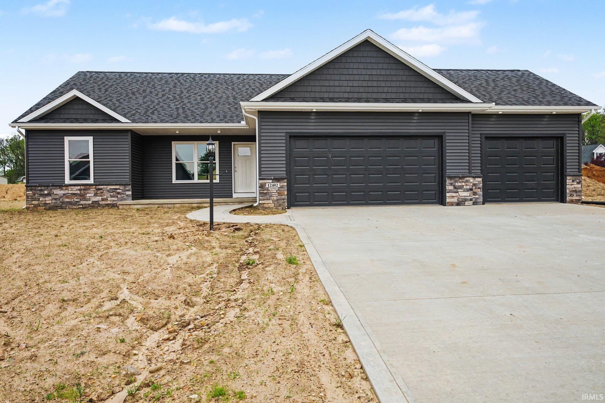 Image 1: Contemporary exterior featuring dark gray siding, complementary stone accents, a multi-car garage, and a concrete driveway, Front Of Structure