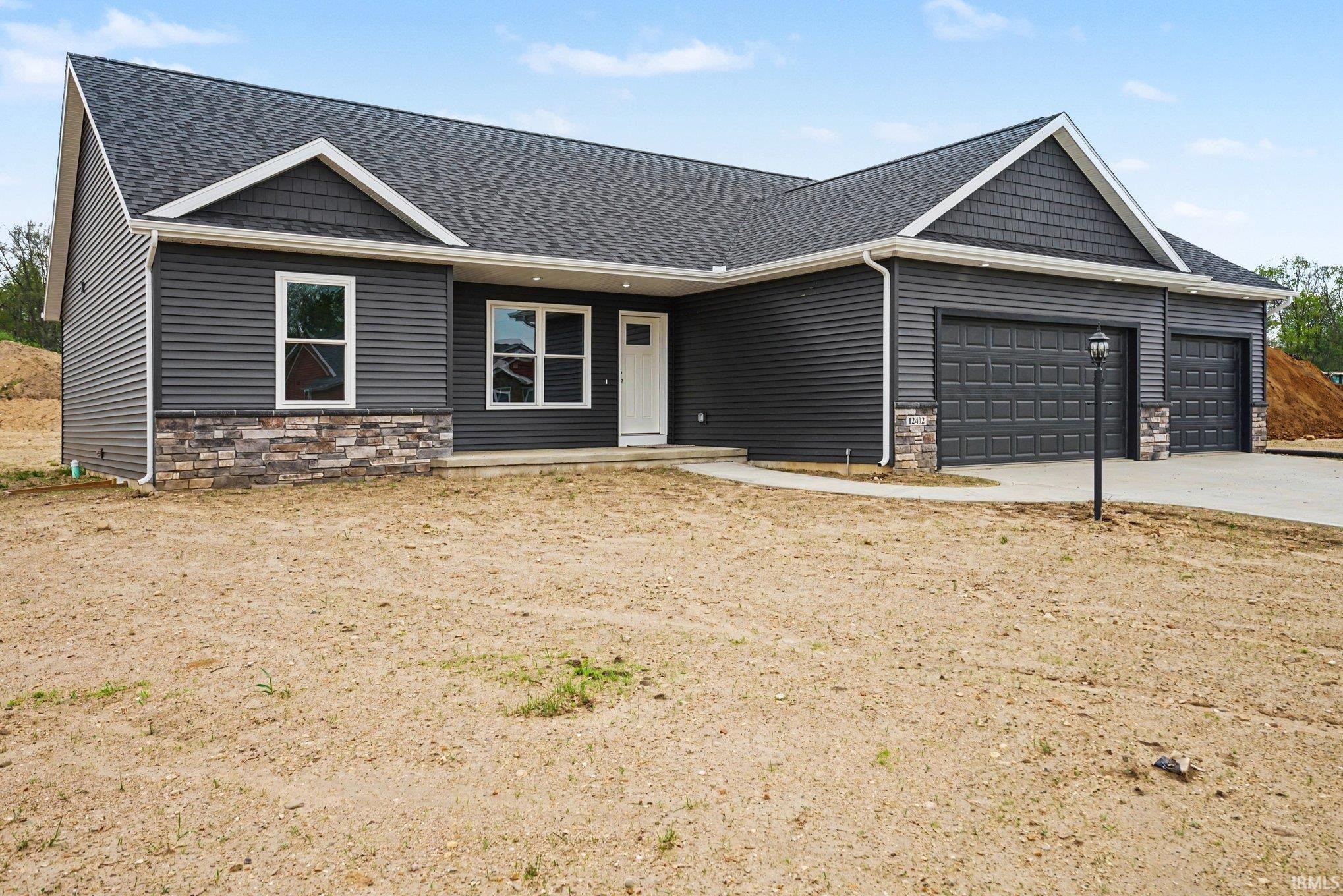 Image 2: Contemporary ranch-style exterior featuring dark gray siding and a stone facade accent, Front Of Structure