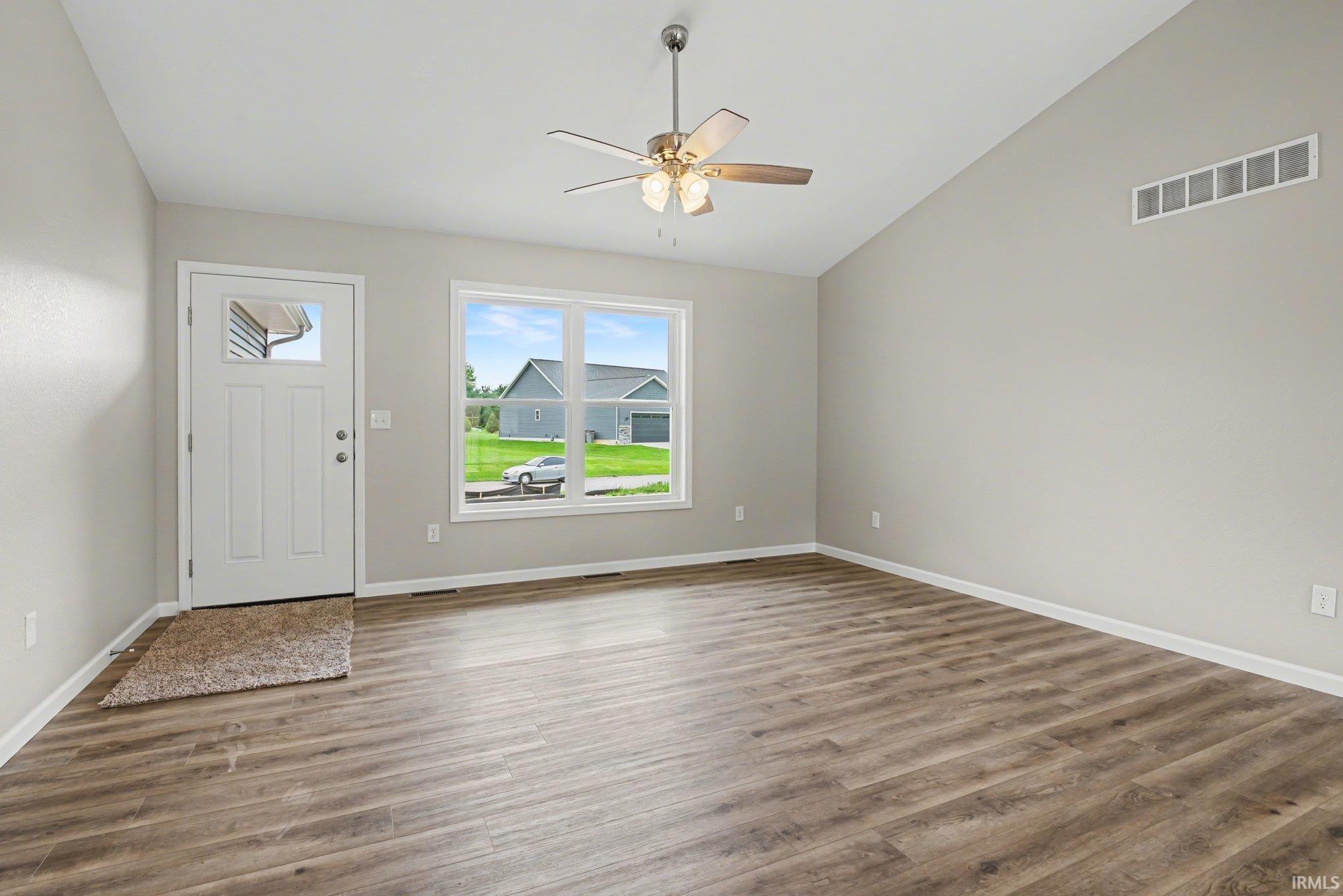 Image 3: Spacious room featuring vaulted ceilings, wood-finish flooring, and a contemporary ceiling fan with integrated lighting, Entrance Foyer