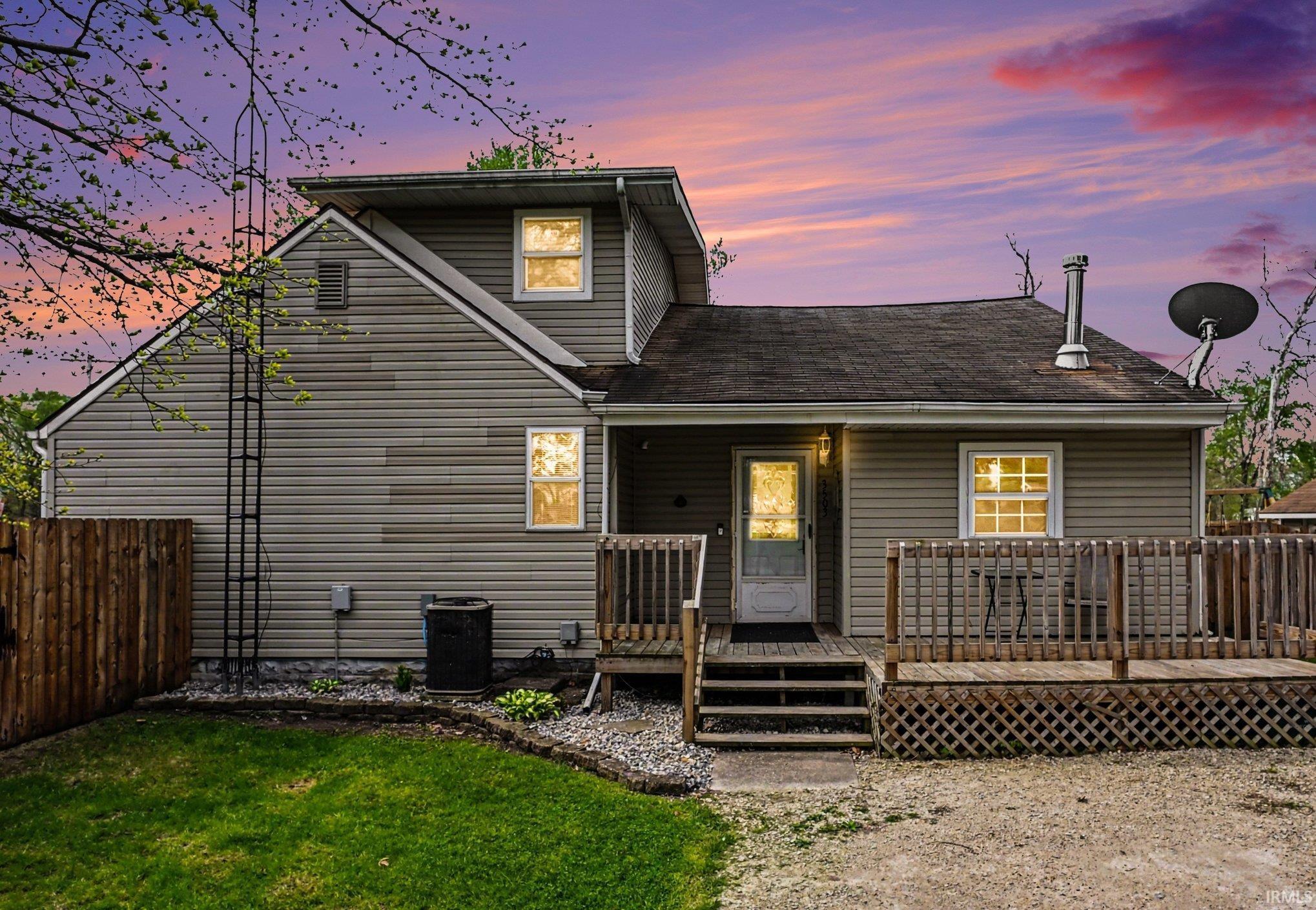 Image 0: gray horizontal siding, a multi-level wood deck, and a fenced yard, View - Primary Front Image 0: gray horizontal siding, a multi-level wood deck, and a fenced yard, View - Primary Front