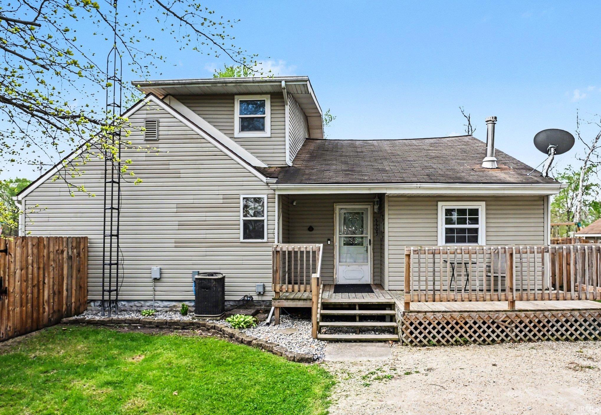 Image 1: Rear exterior with light-colored horizontal siding and a wood deck, View - Primary Front Image 1: Rear exterior with light-colored horizontal siding and a wood deck, View - Primary Front