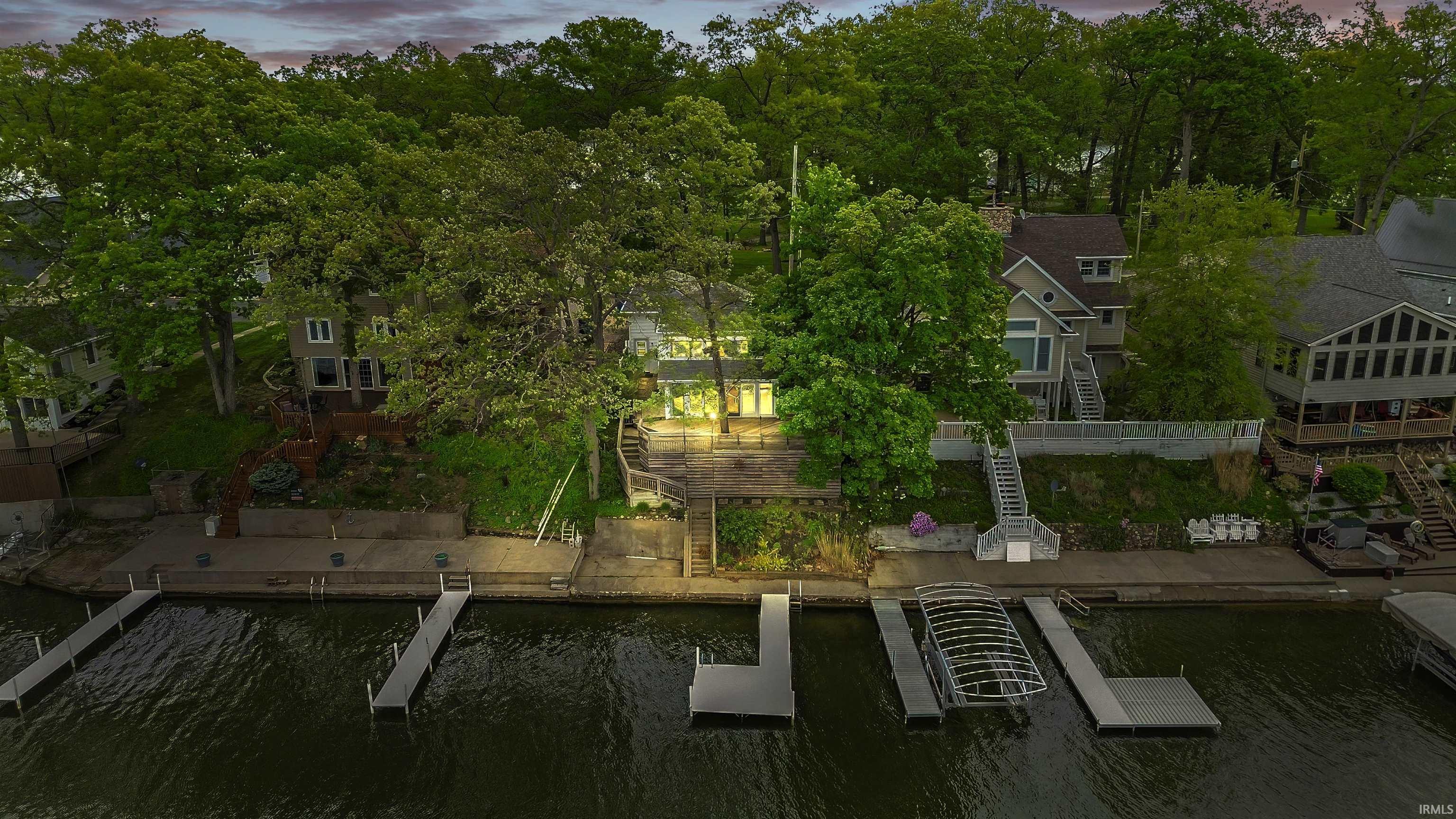Image 2: Waterfront property featuring a private dock, boathouse, and mature trees, Aerial View Image 2: Waterfront property featuring a private dock, boathouse, and mature trees, Aerial View