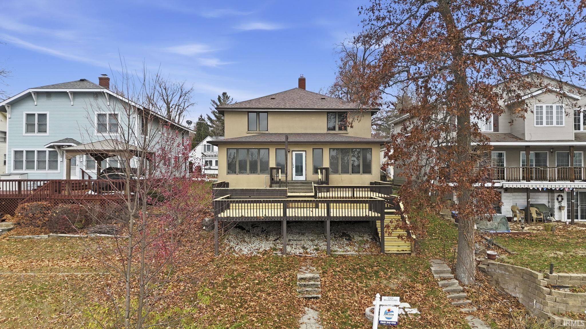 Image 1: Rear view of house with a wooden deck, stairway, a gazebo, a chimney, and a shingled roof, Back Of Structure