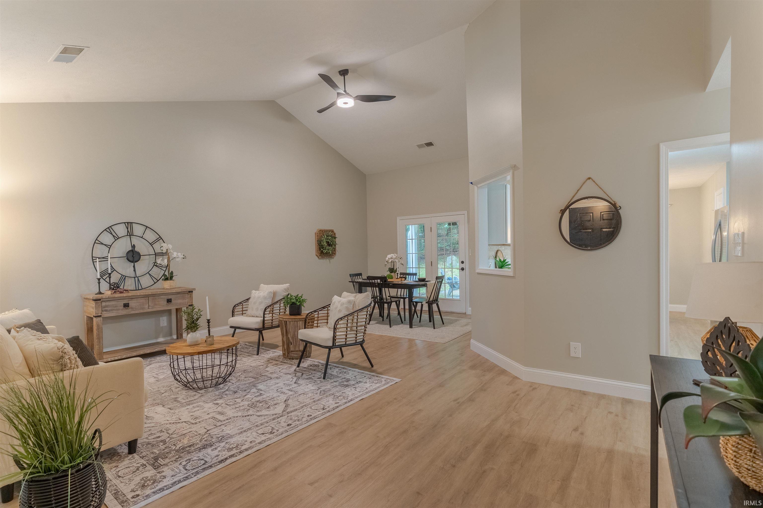 Image 2: Sitting room with light wood-style flooring, high vaulted ceiling, a ceiling fan, and french doors, Sitting Room