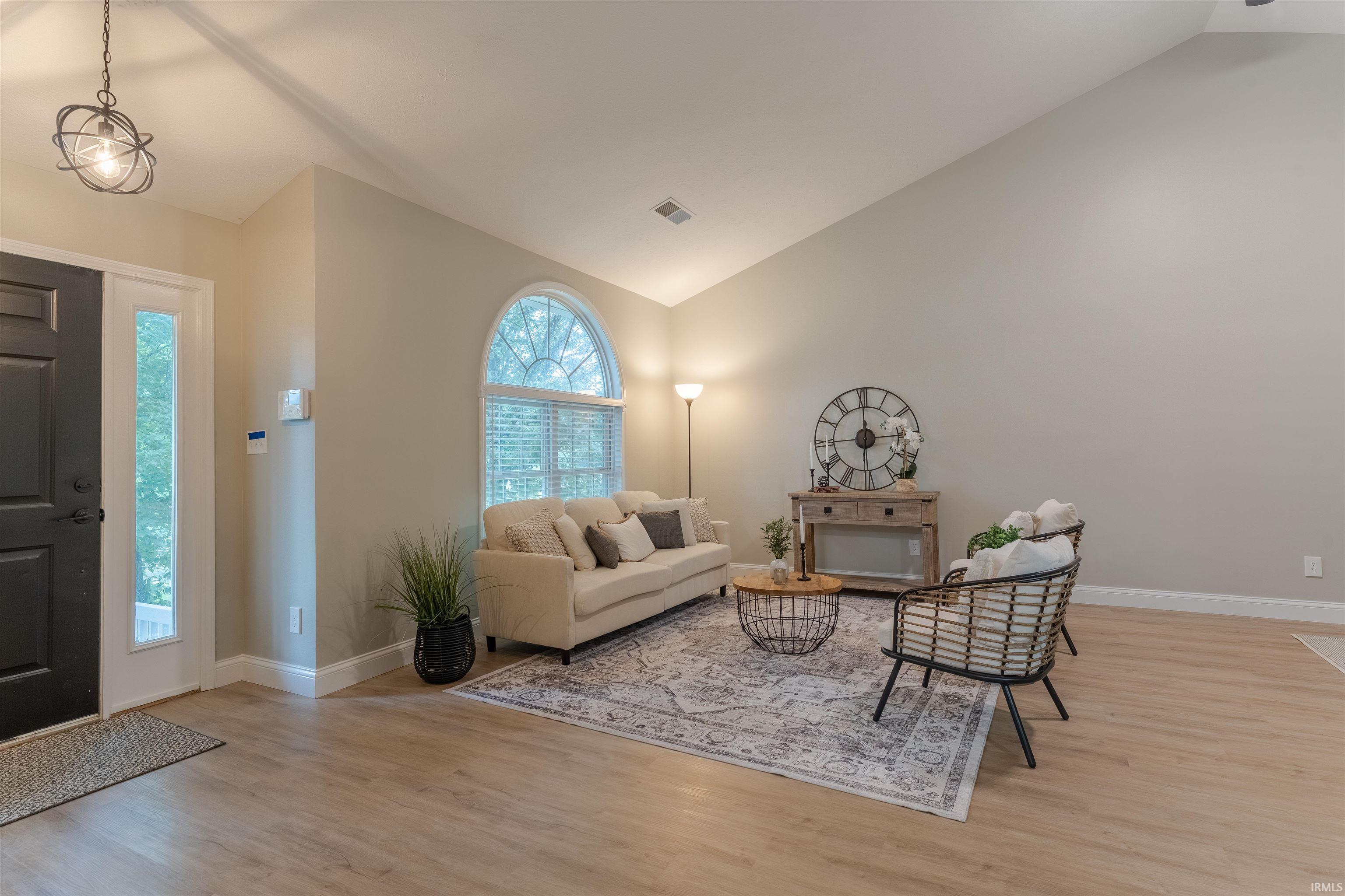 Image 3: Living area featuring light wood-type flooring and high vaulted ceiling, Living Room
