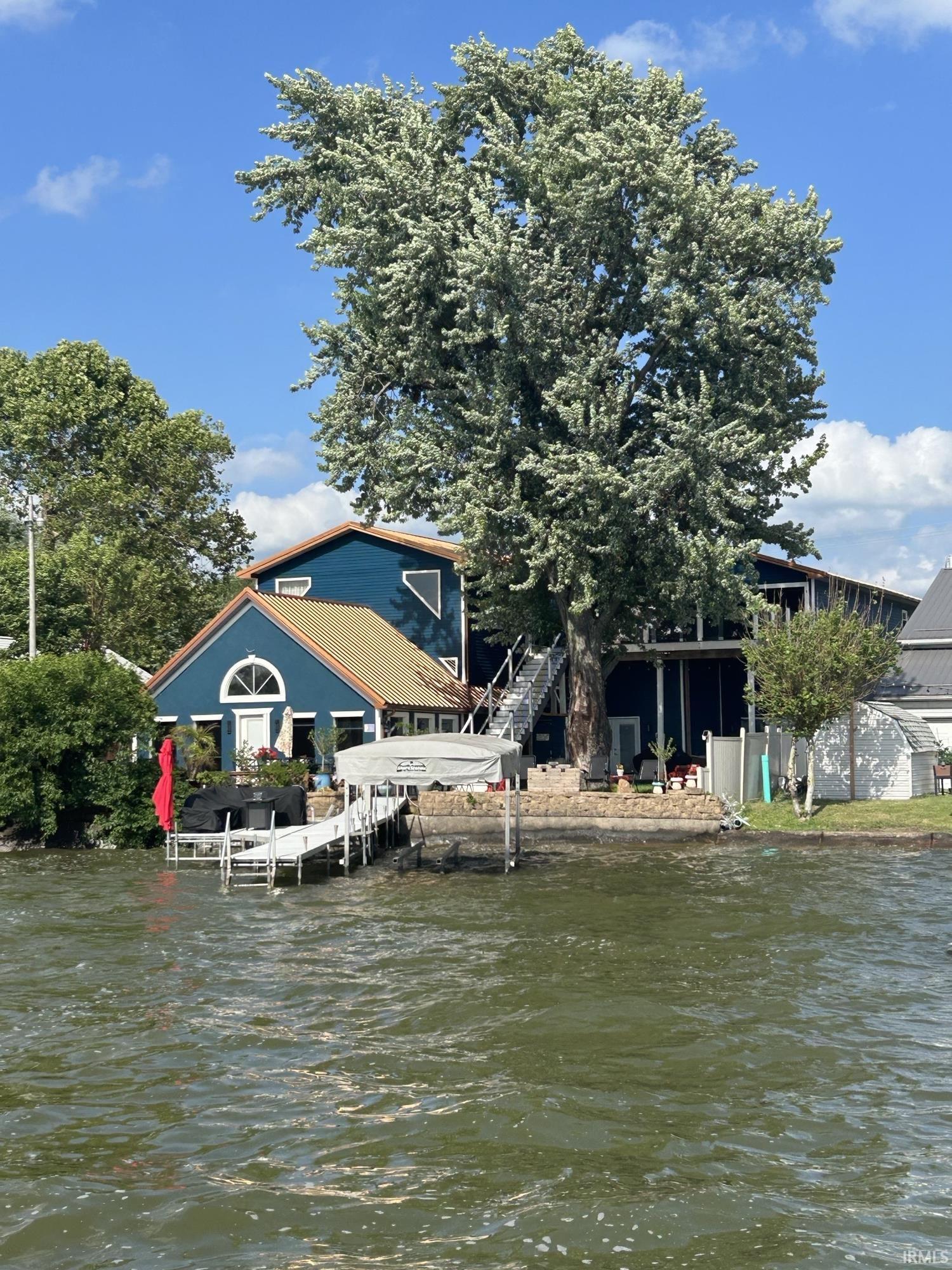 Image 1: Dock area featuring a water view and stairs, Dock