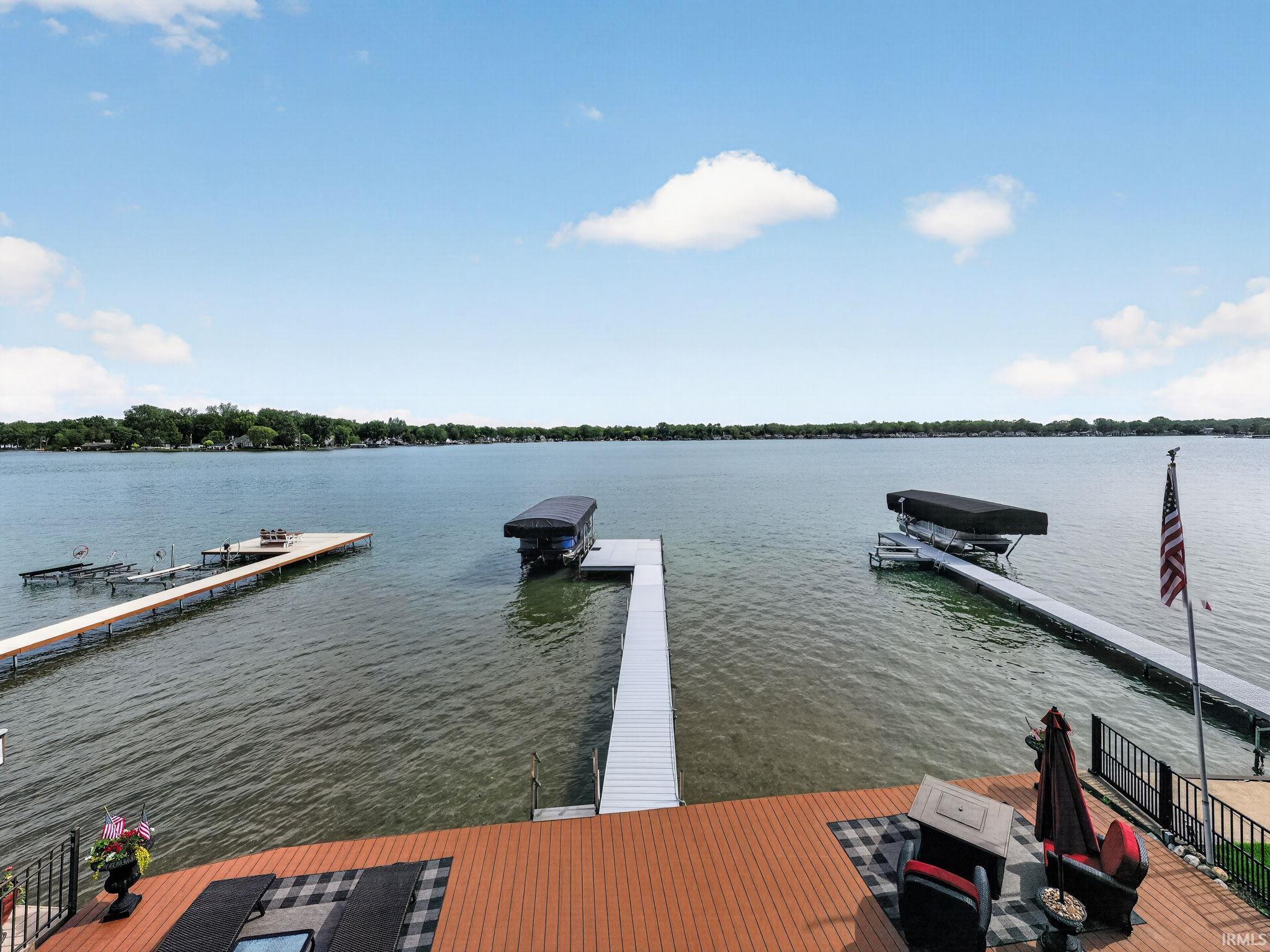 Image 1: Expansive lakefront property featuring a composite deck, multiple docks, and two covered boat lifts, Dock