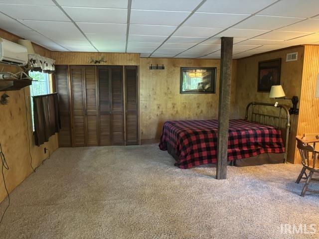 Image 1: Carpeted interior space featuring wood-paneled walls and a drop ceiling, Bedroom