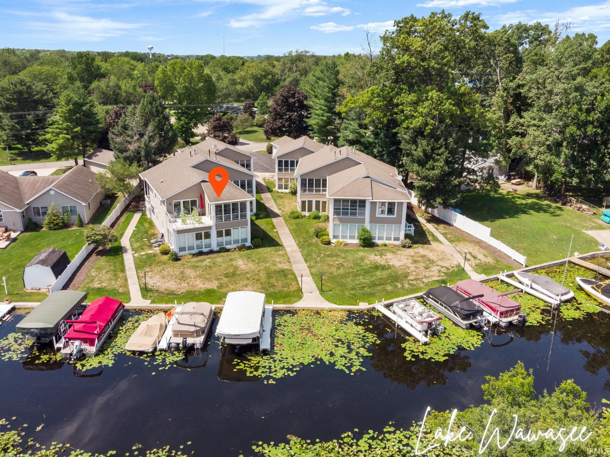 Image 0: Aerial view of property and surrounding area featuring a nearby body of water, Lake Wawasee