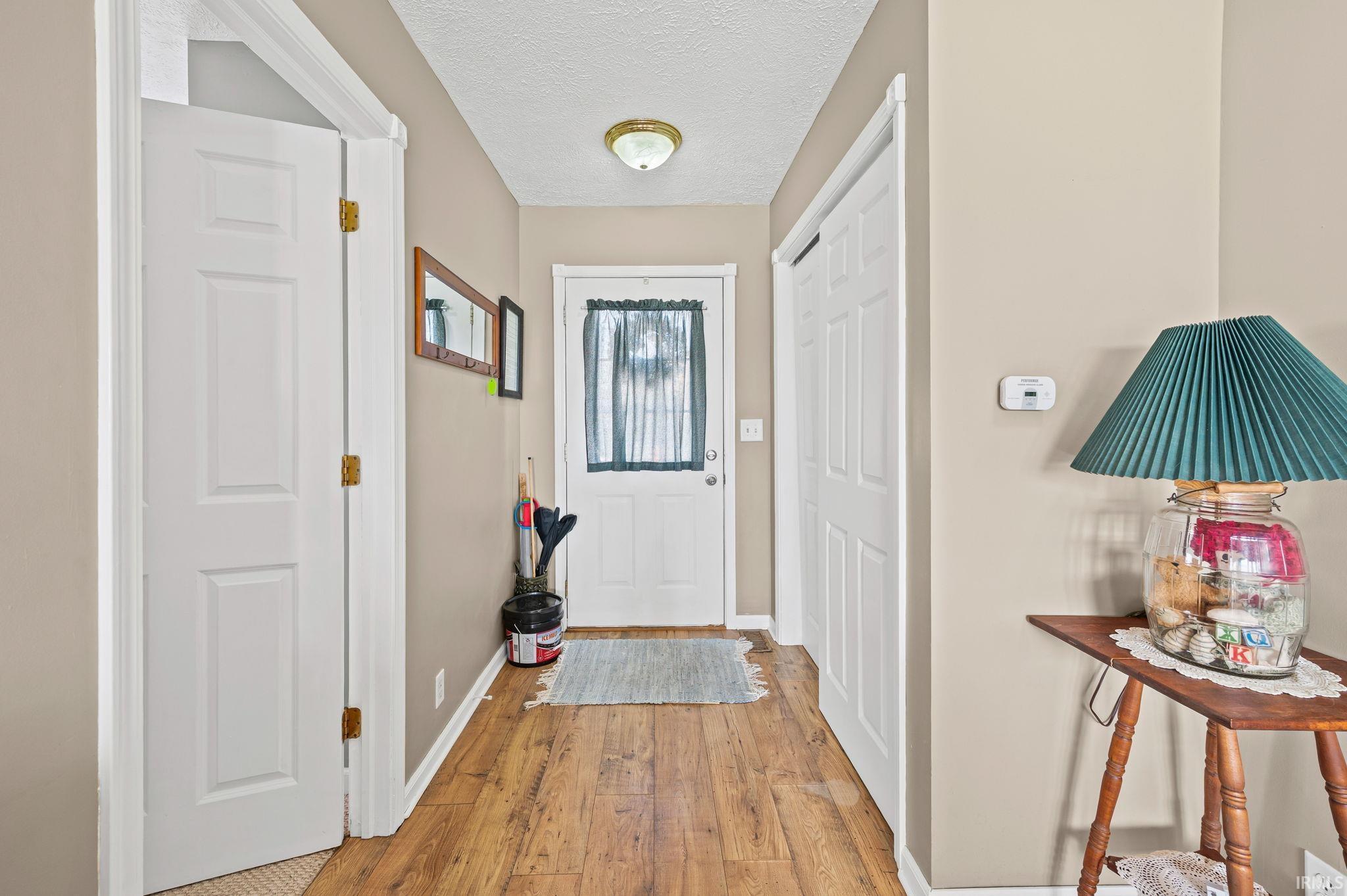 Image 1: Doorway with a textured ceiling and wood-type flooring, Entry