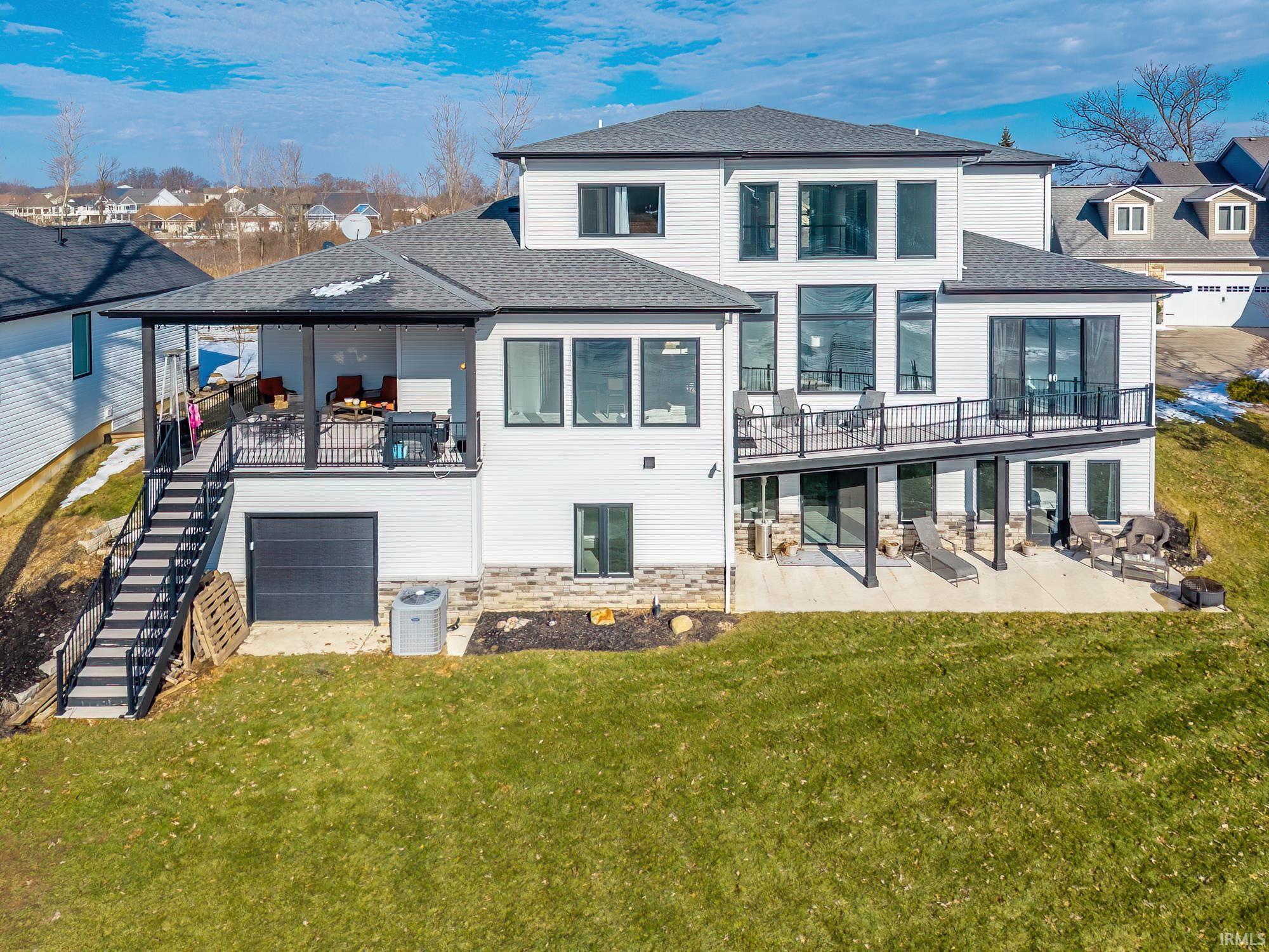 Image 1: Back of house with roof with shingles, a patio area, a yard, a residential view, and an attached garage, Back Of Structure