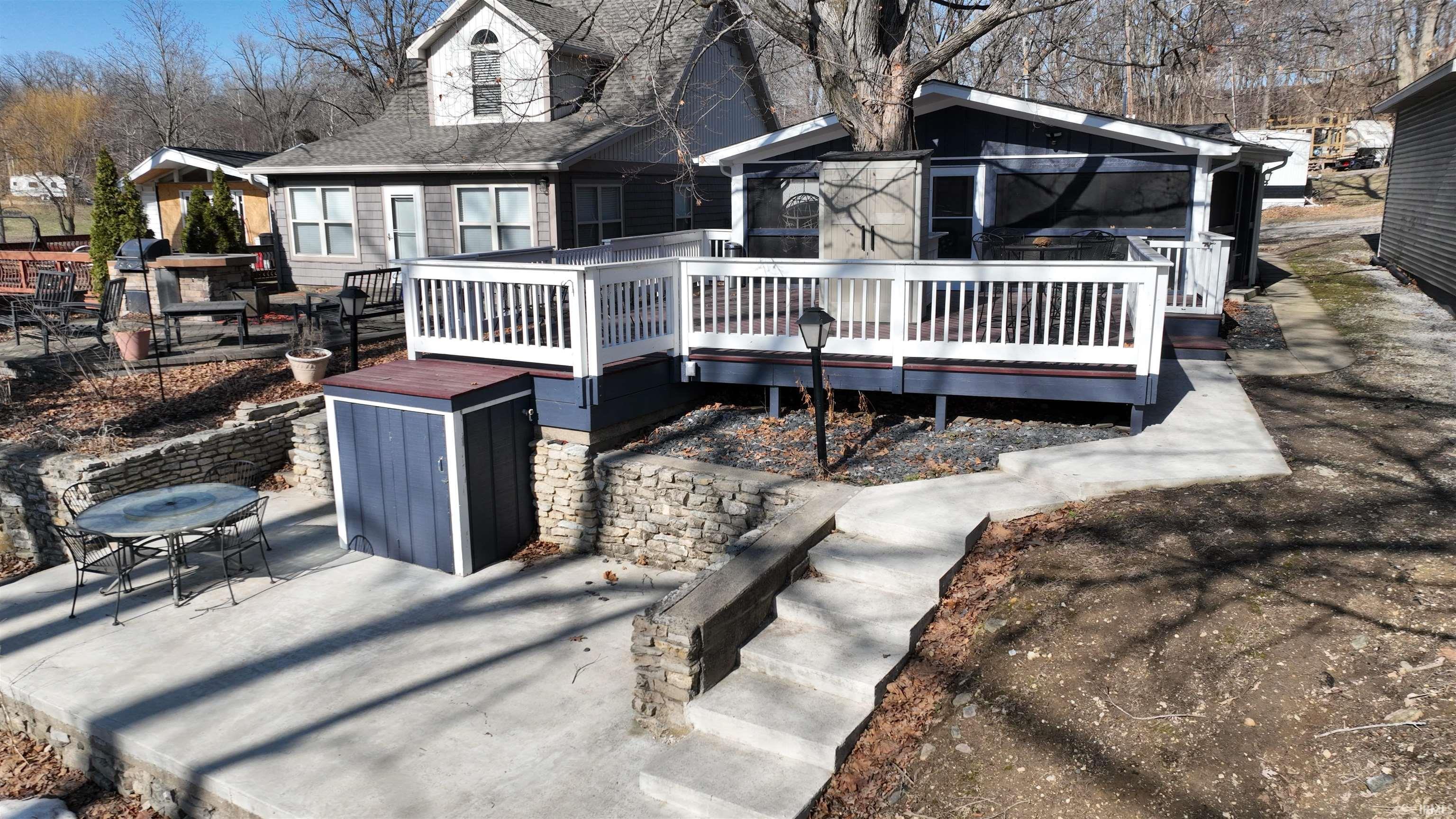Image 0: Back of house featuring a deck, a patio area, and roof with shingles, Back Of Structure