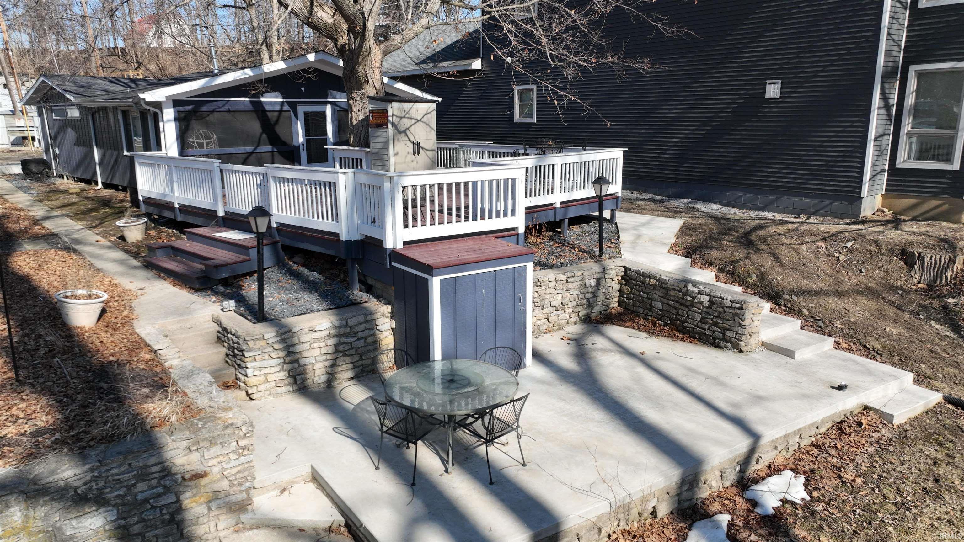 Image 2: Back of house featuring a wooden deck, outdoor dining area, and a patio, Back Of Structure