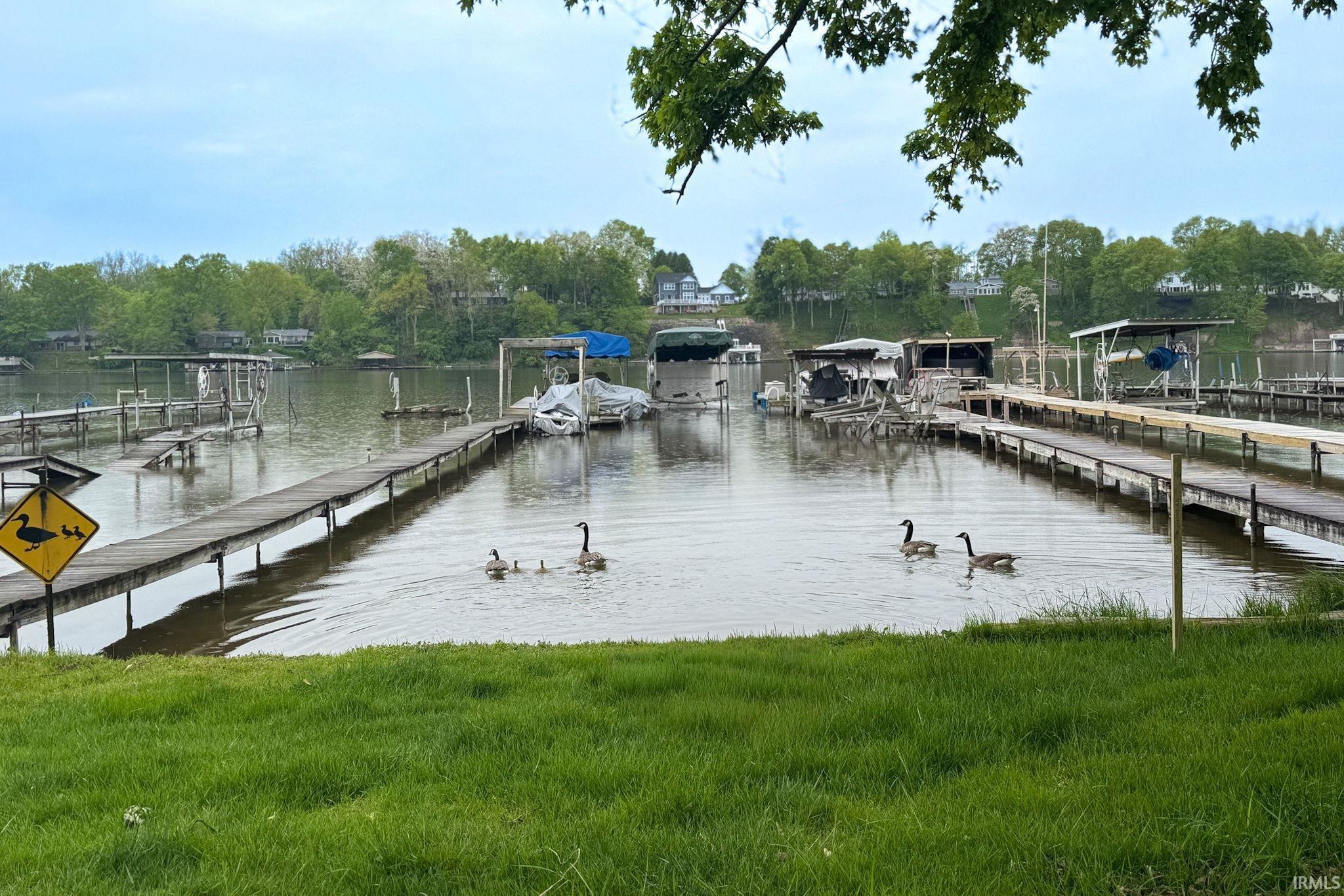 Image 1: Waterfront property featuring multiple boat docks and covered slips, Dock Image 1: Waterfront property featuring multiple boat docks and covered slips, Dock