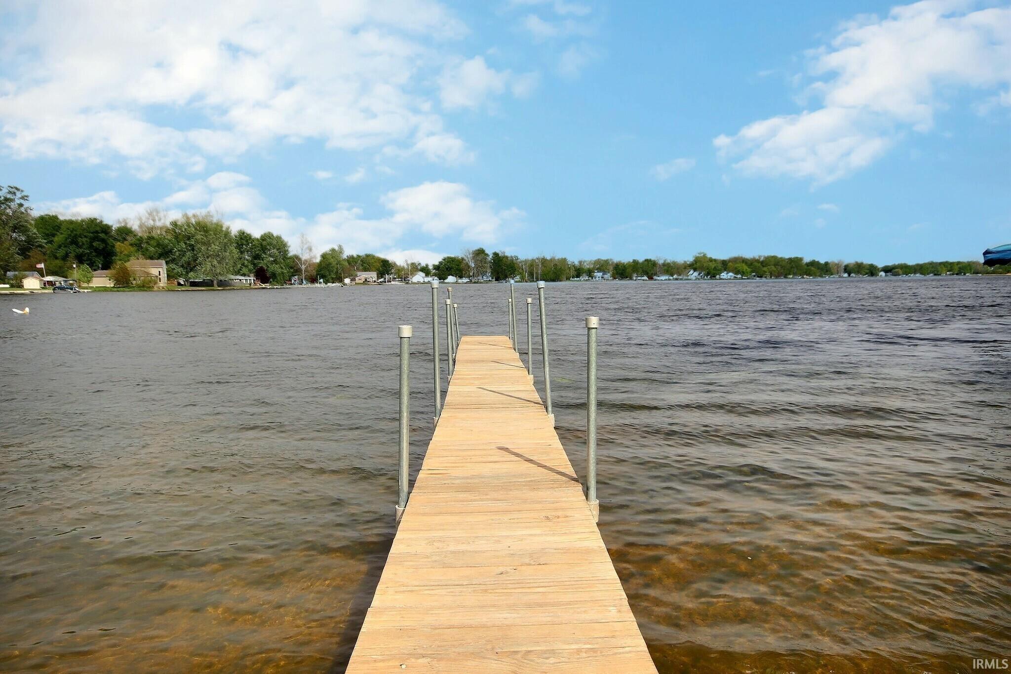 Image 1: Private dock extending into a body of water with a clear sky overhead, Dock Image 1: Private dock extending into a body of water with a clear sky overhead, Dock