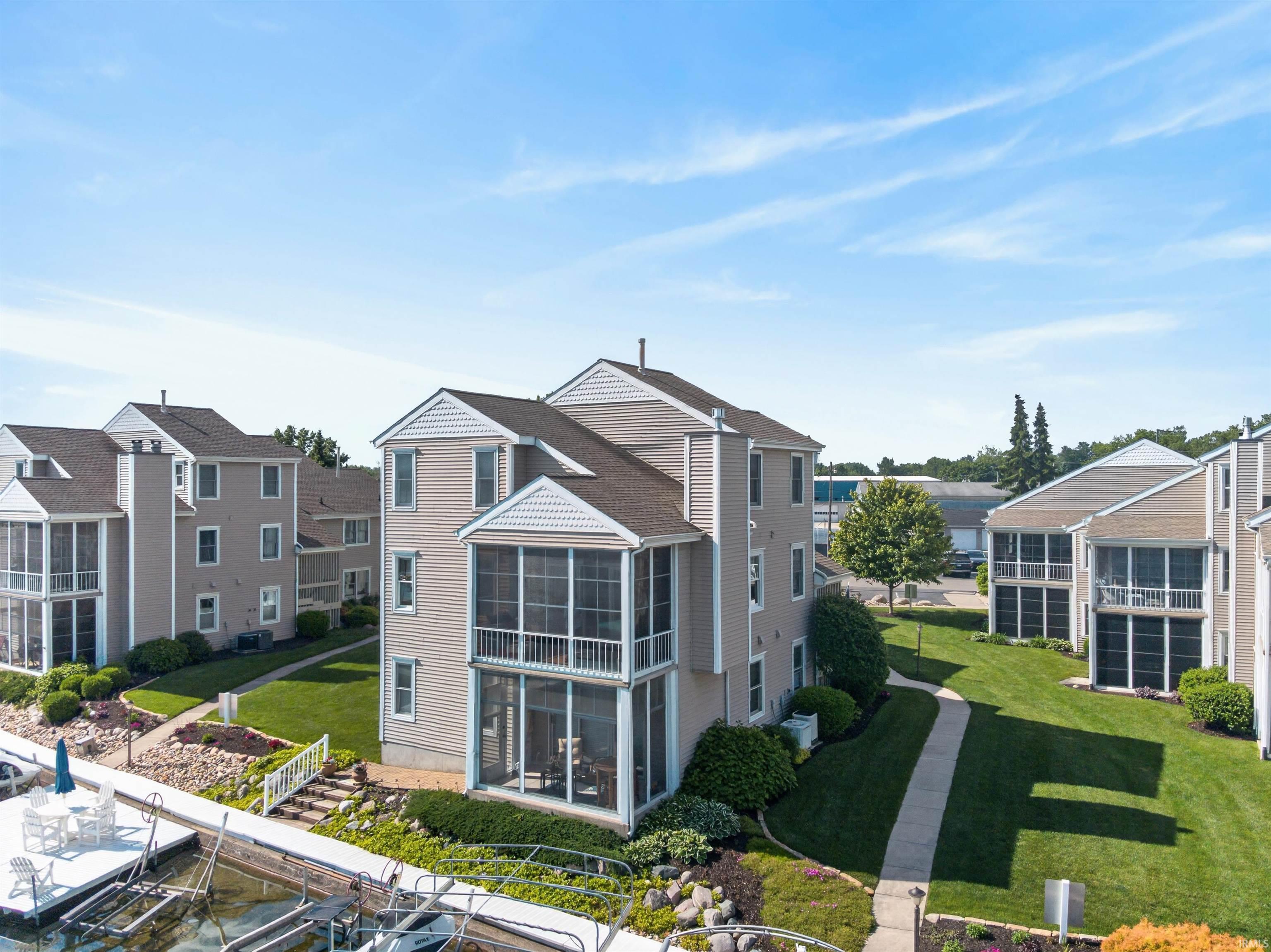 Image 1: Waterfront property featuring multiple screened-in porches, direct dock access, manicured lawns, and mature landscaping, Back Of Structure