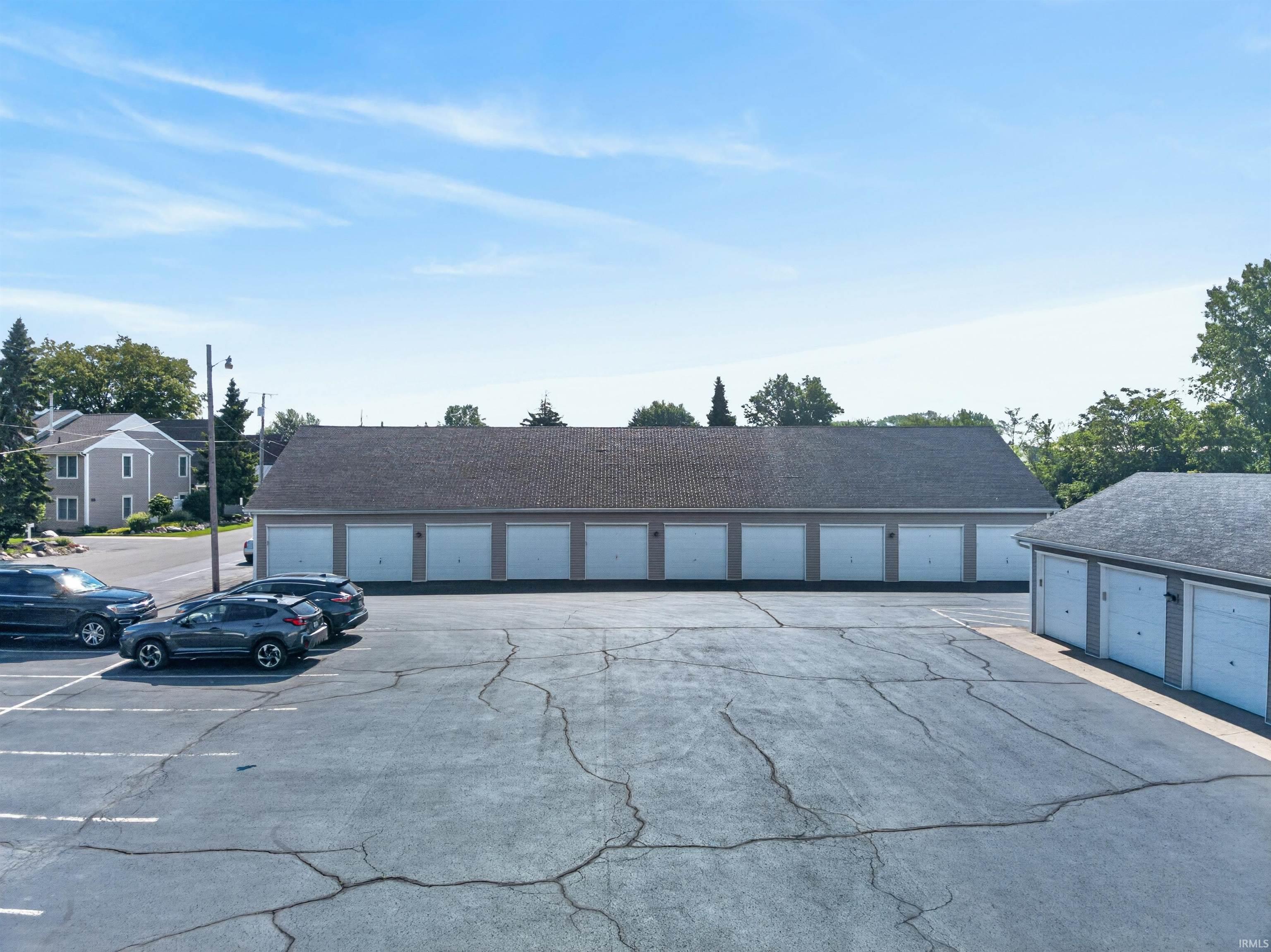 Image 3: Long building featuring multiple garage bays with white doors, Parking