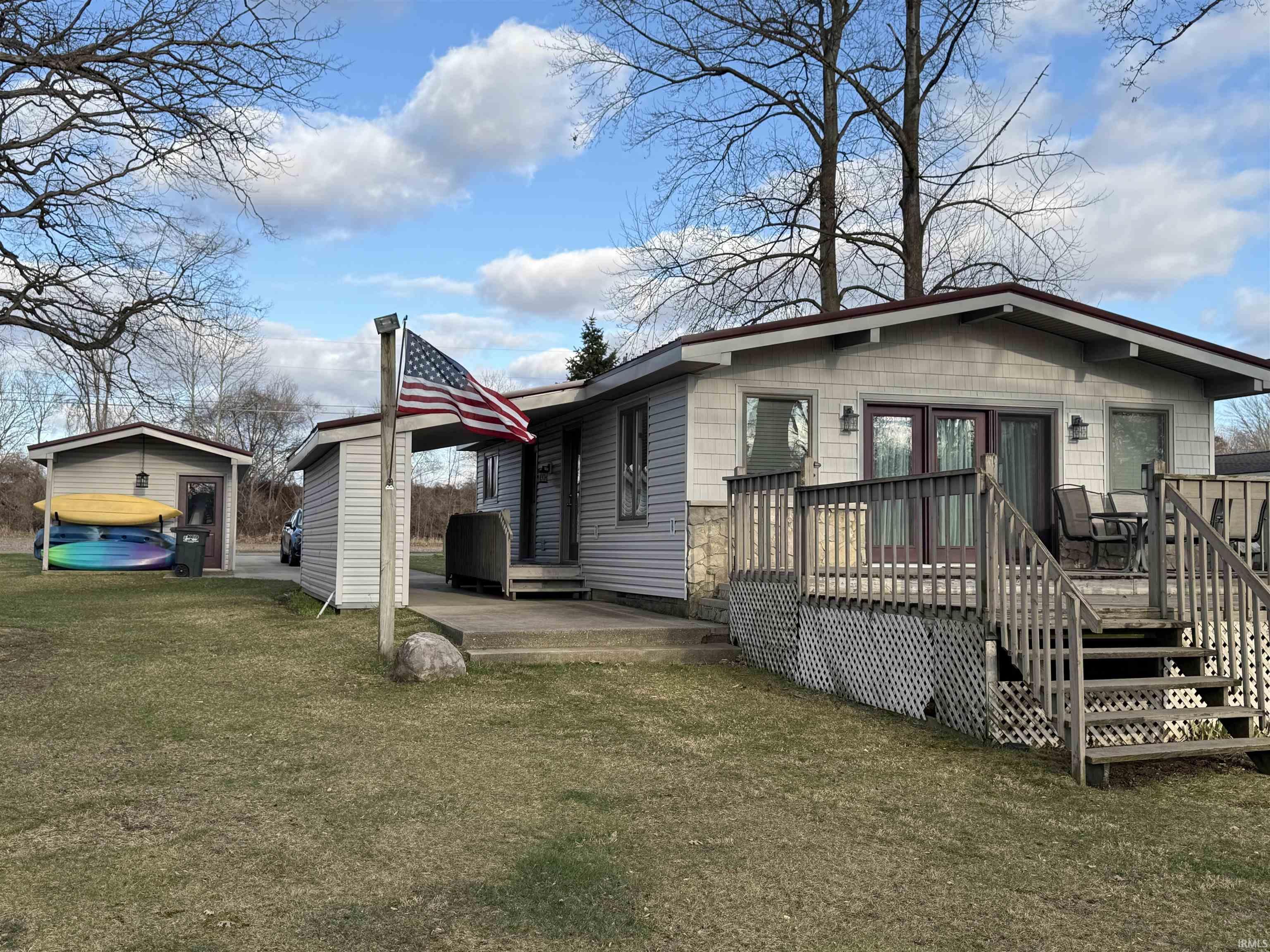Image 0: Front of property featuring a deck and a lawn (Lakefront), Front of Structure