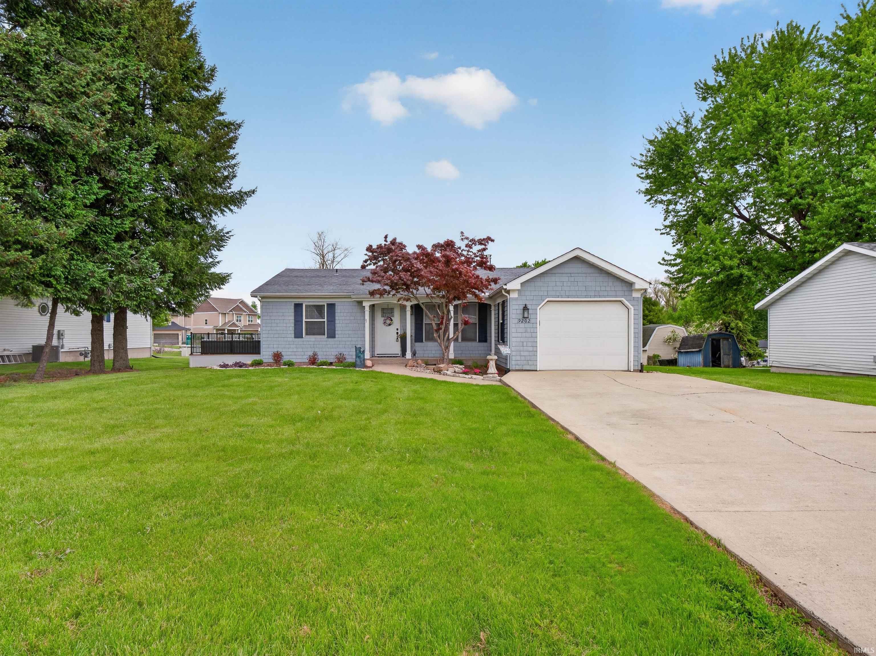 Image 0: Light blue shingle siding exterior featuring a white garage door, concrete driveway, and a manicured front lawn, Front Of Structure Image 0: Light blue shingle siding exterior featuring a white garage door, concrete driveway, and a manicured front lawn, Front Of Structure